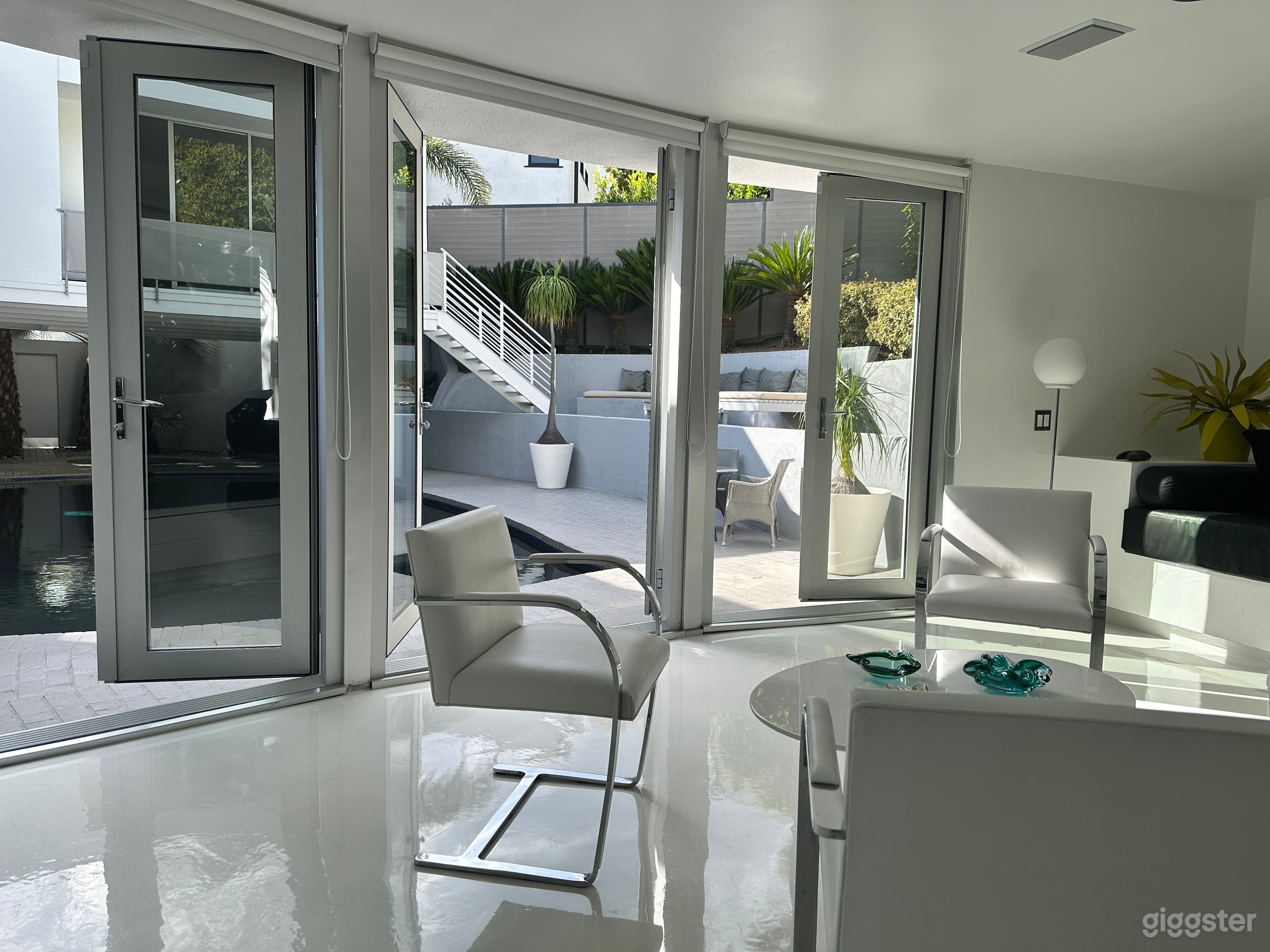 Cabana views across the pool  toward main house primary bedroom entrance and upper pool deck and garden. 