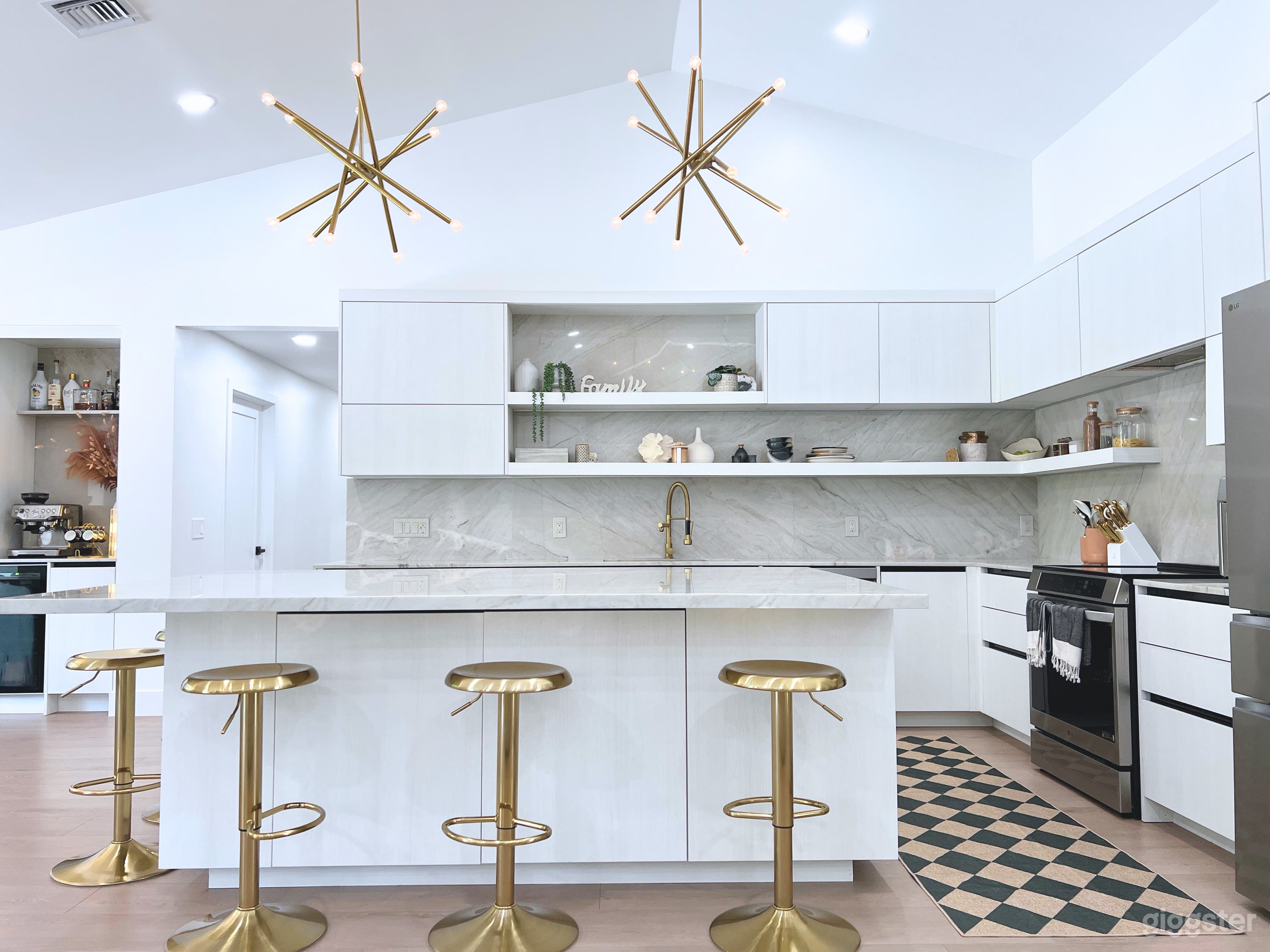 Textured wood grain large modern kitchen with 5 brass bar stools. 