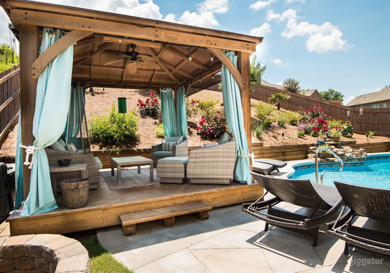 Pavilion in the backyard. Fence and pavilion were recently painted after this picture to a dark brown and curtains are now grey. 