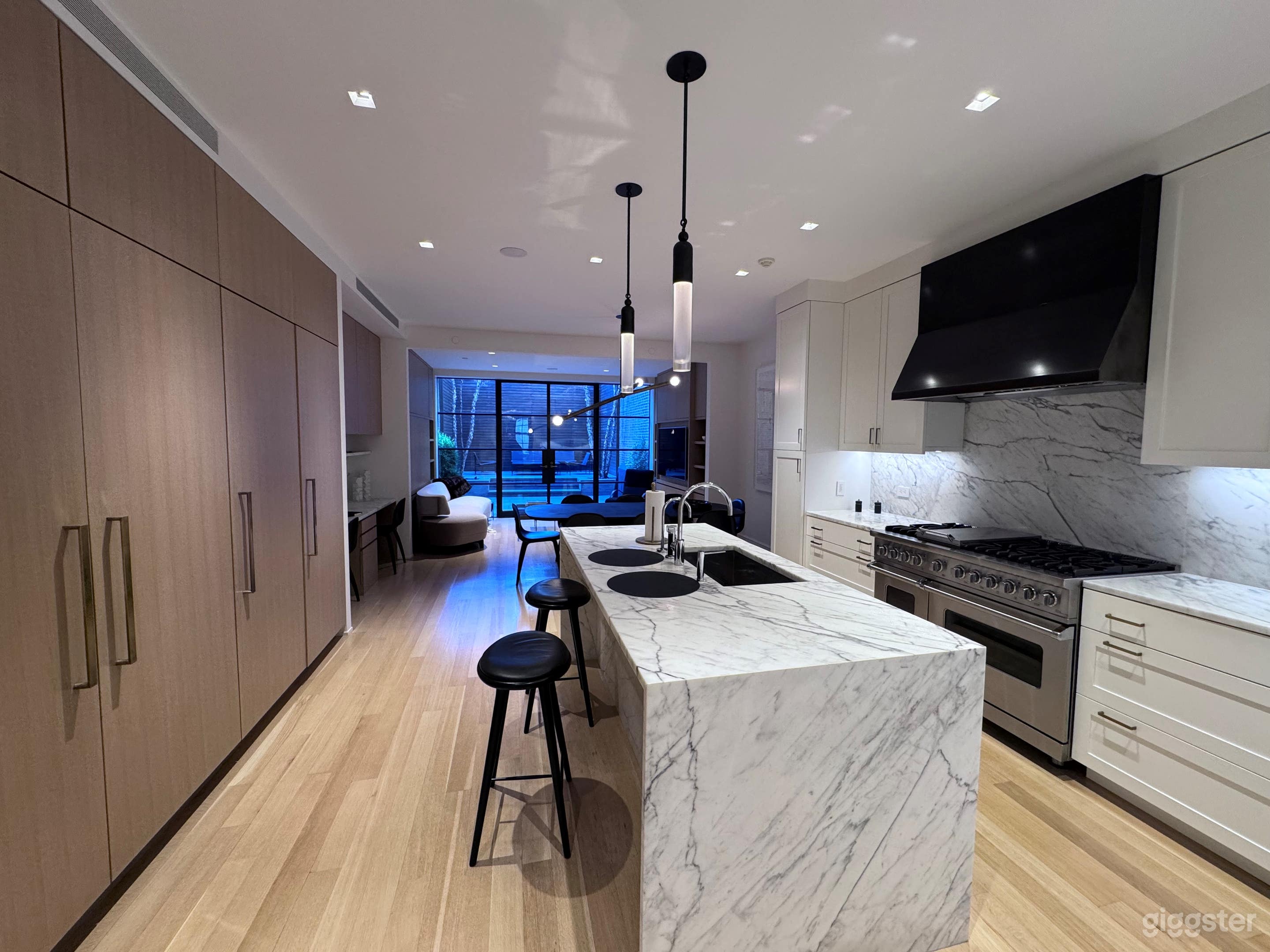 Open kitchen, dining area and family room with glass wall to rear garden