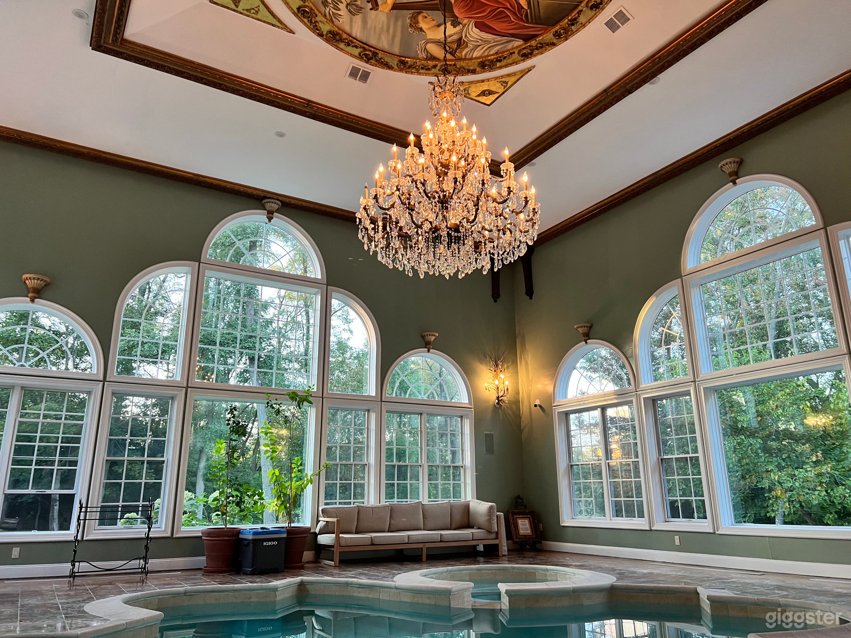 Indoor pool (roughly 32’x30’ room dimensions) with large crystal chandelier, mural and lots of windows.
