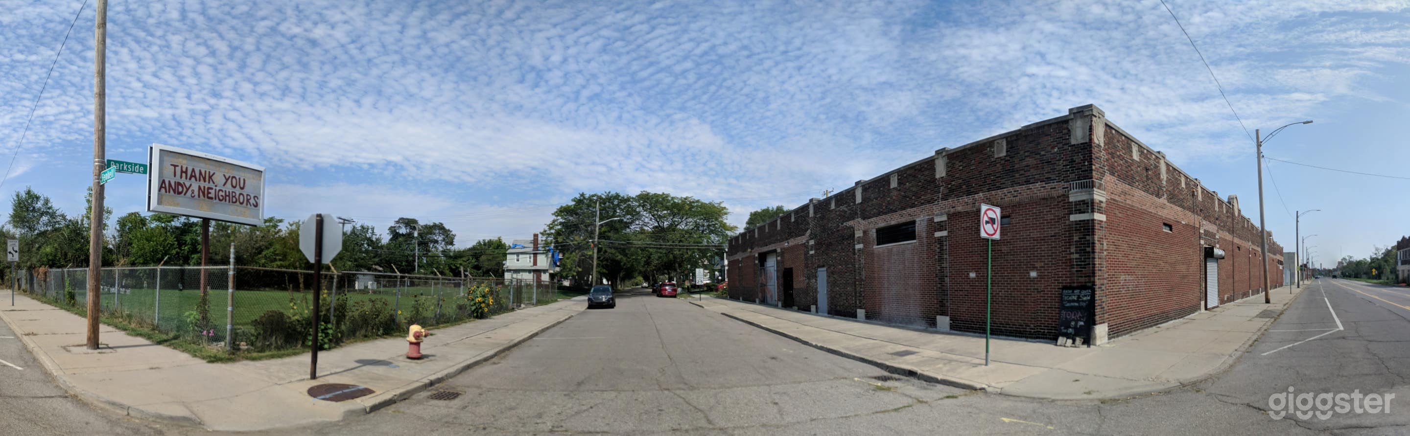 Building facade, fenced parking opposite side of street