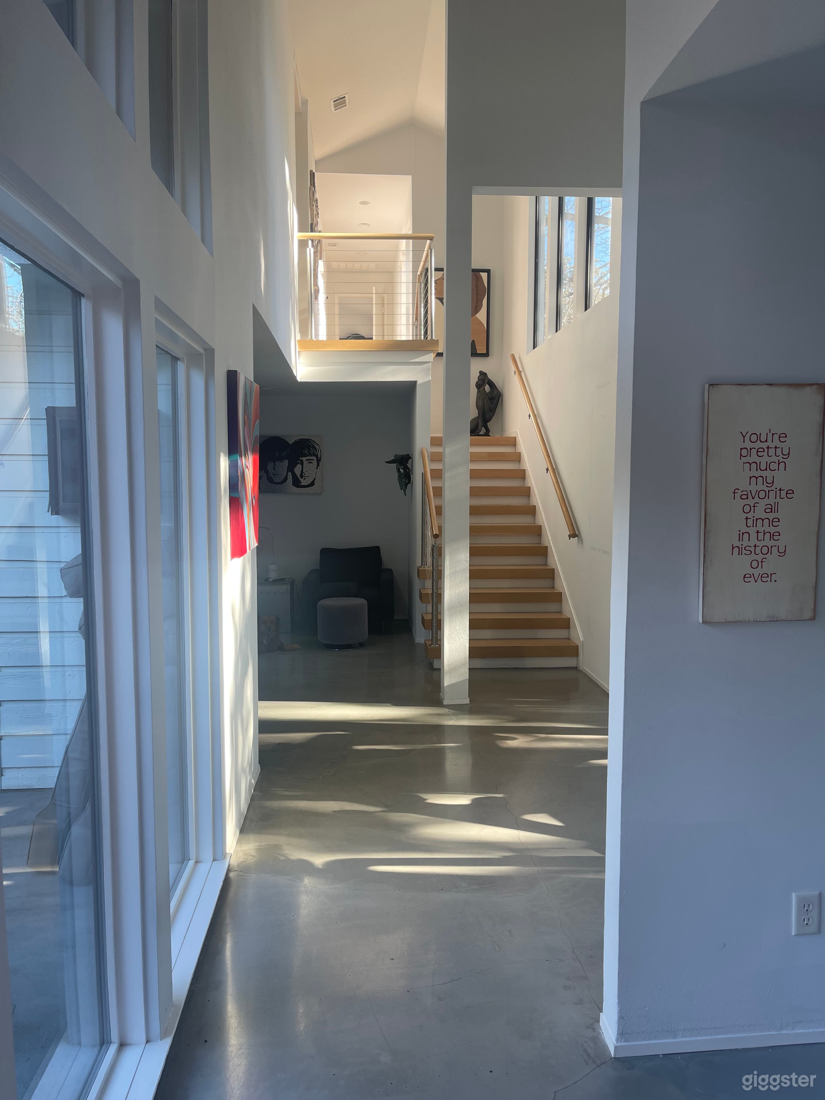 Other side of the house small hallway of windows that leads to the workout area, stairs and kitchen