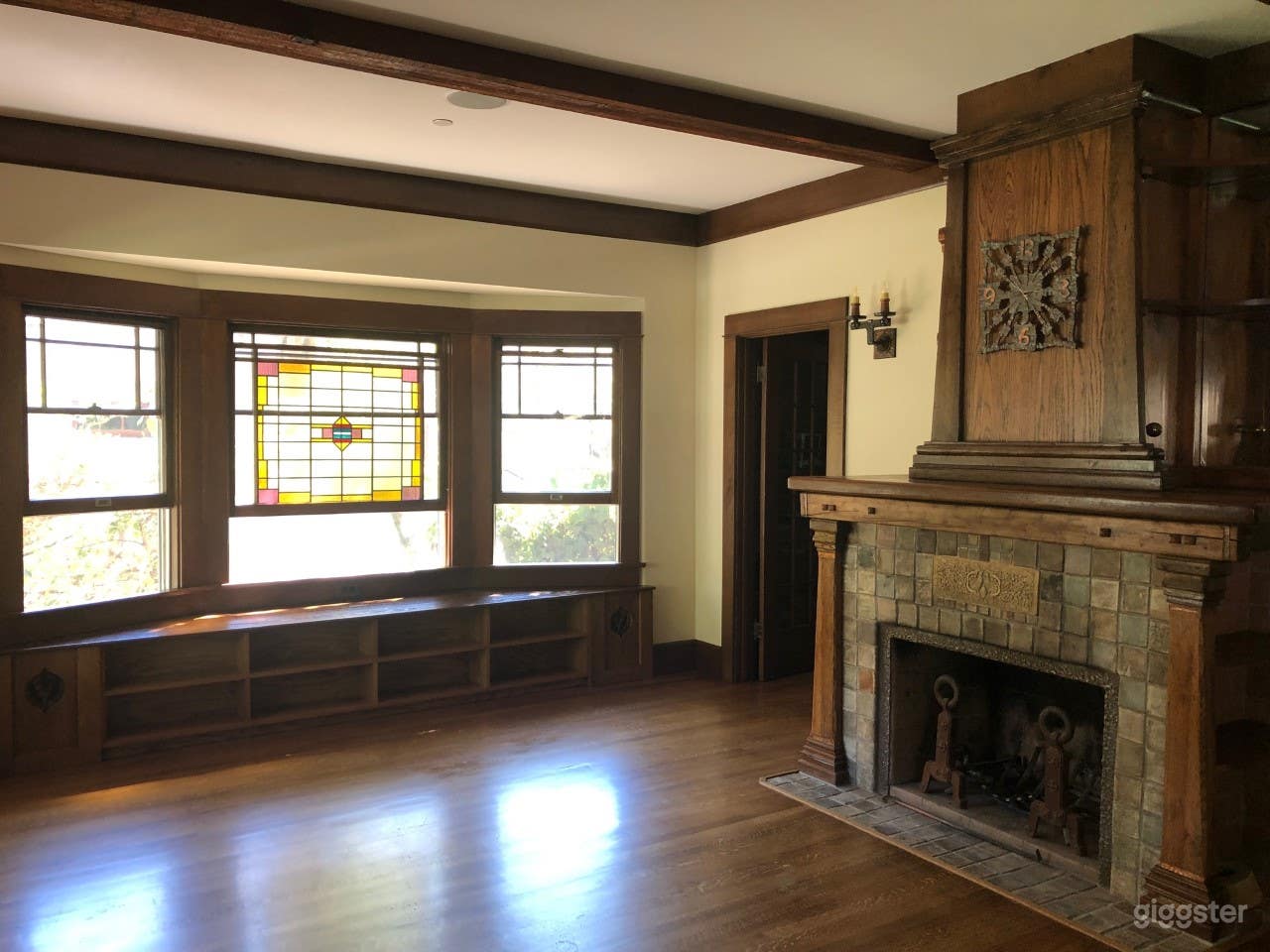 Living room with fireplace and stained glass window.
