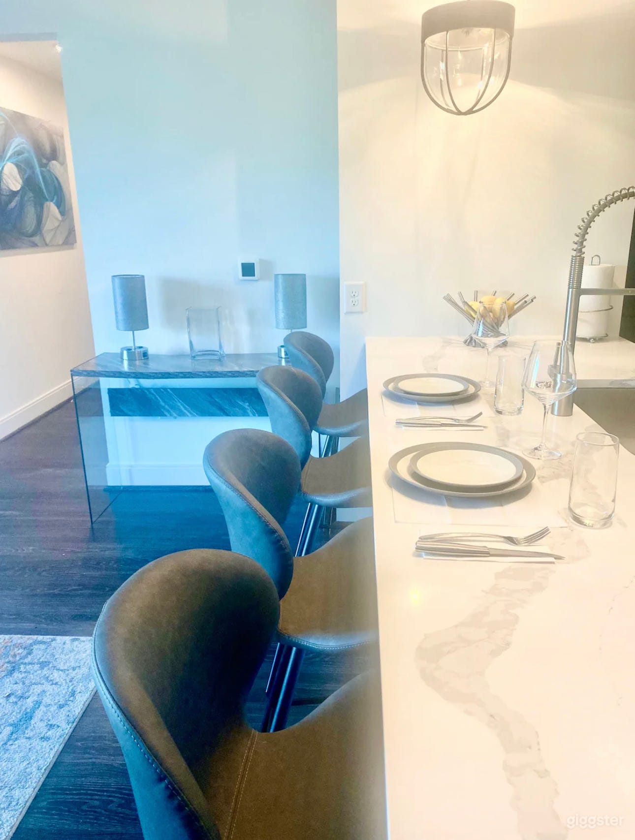 A spacious kitchen dining table set for guests presents an inviting and elegant atmosphere. The table is large enough to accommodate several guests comfortably and is adorned with a stylish, quality tablecloth or runner. 