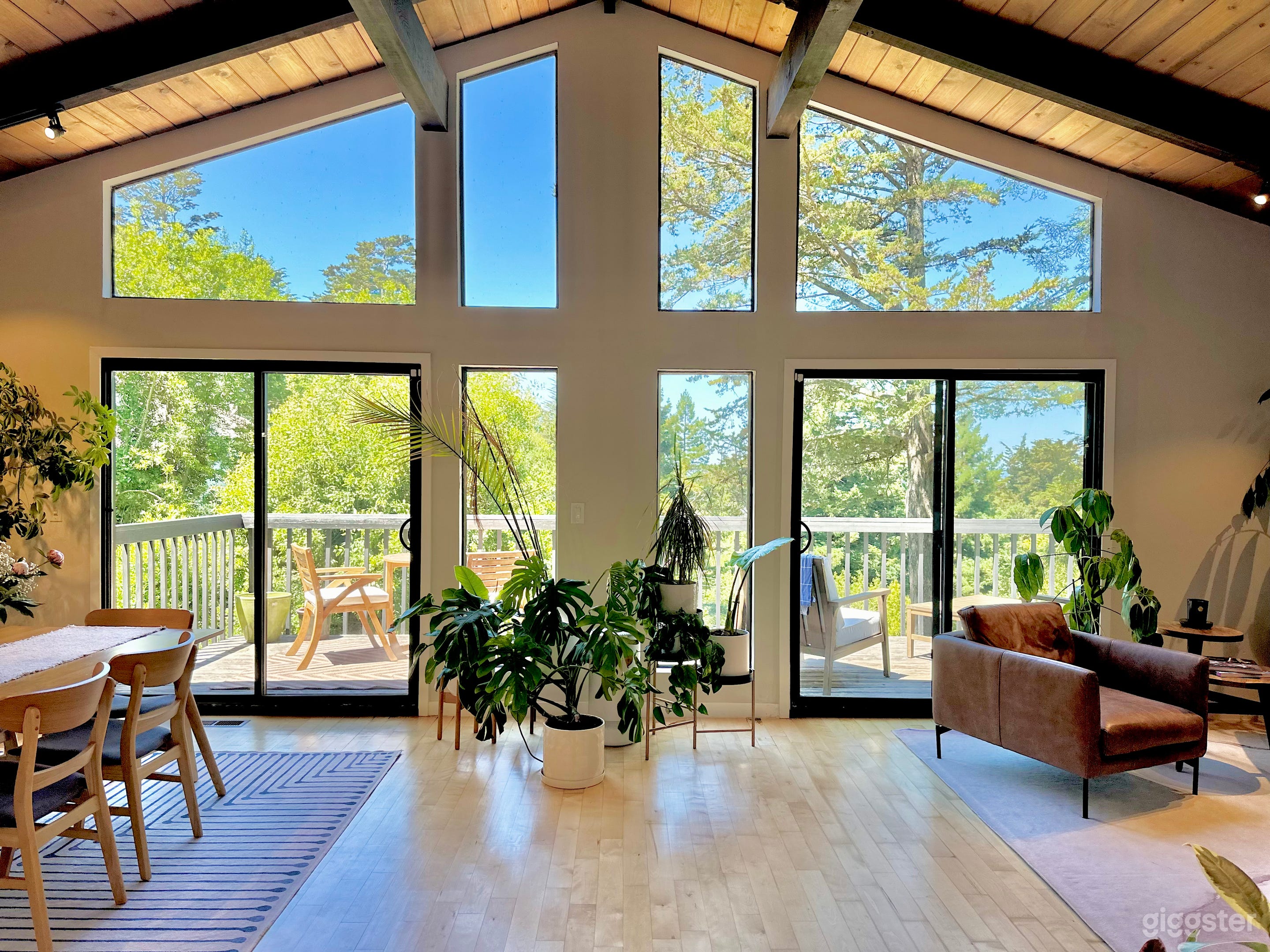 Nestled amongst towering trees, this stunning open-concept home offers a tranquil retreat with breathtaking views. Sunlight pours through custom floor-to-ceiling windows, illuminating the spacious living and dining areas.