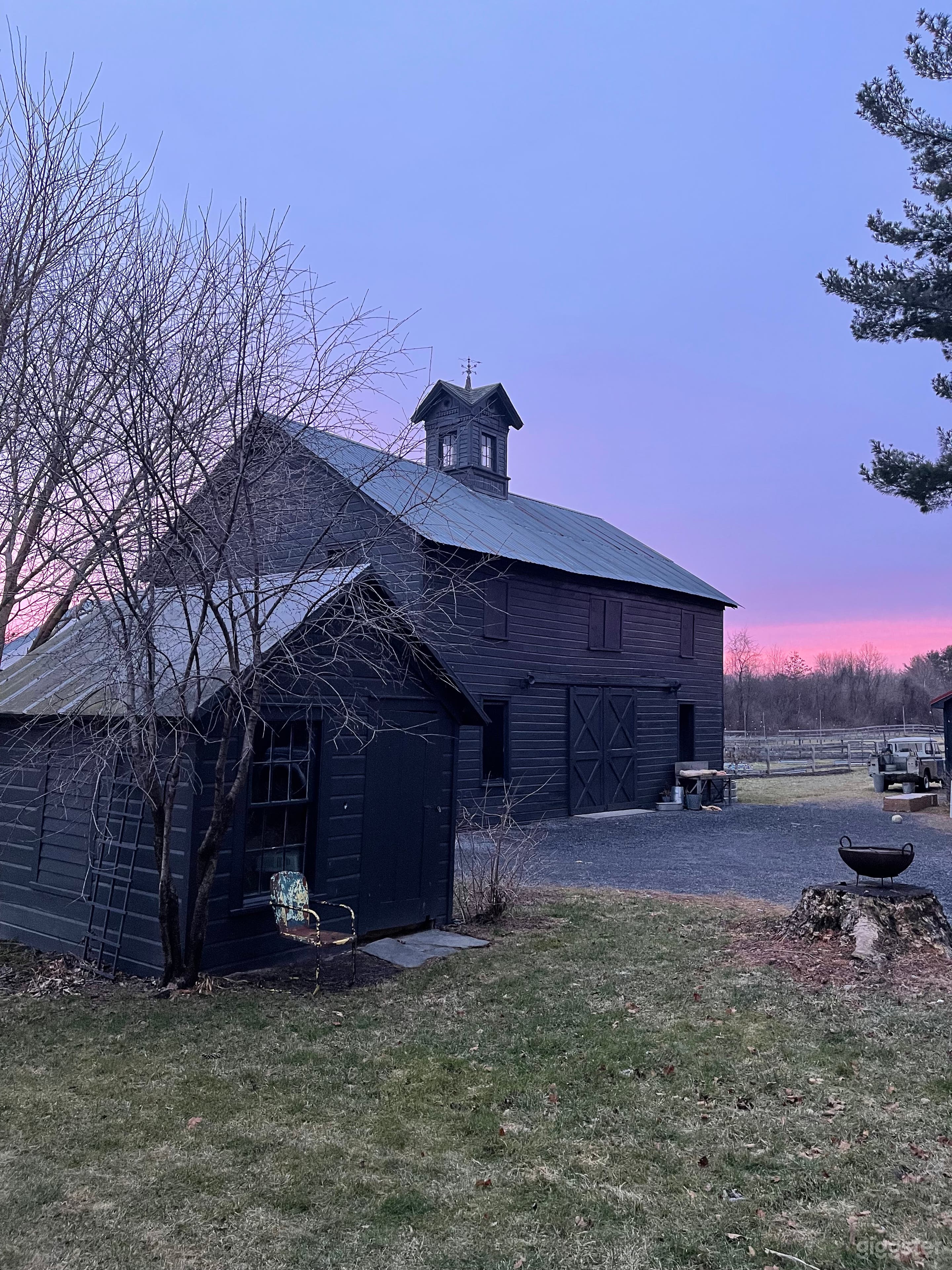 Colorful view of barn, love shack, and courtyard looking from farmhouse