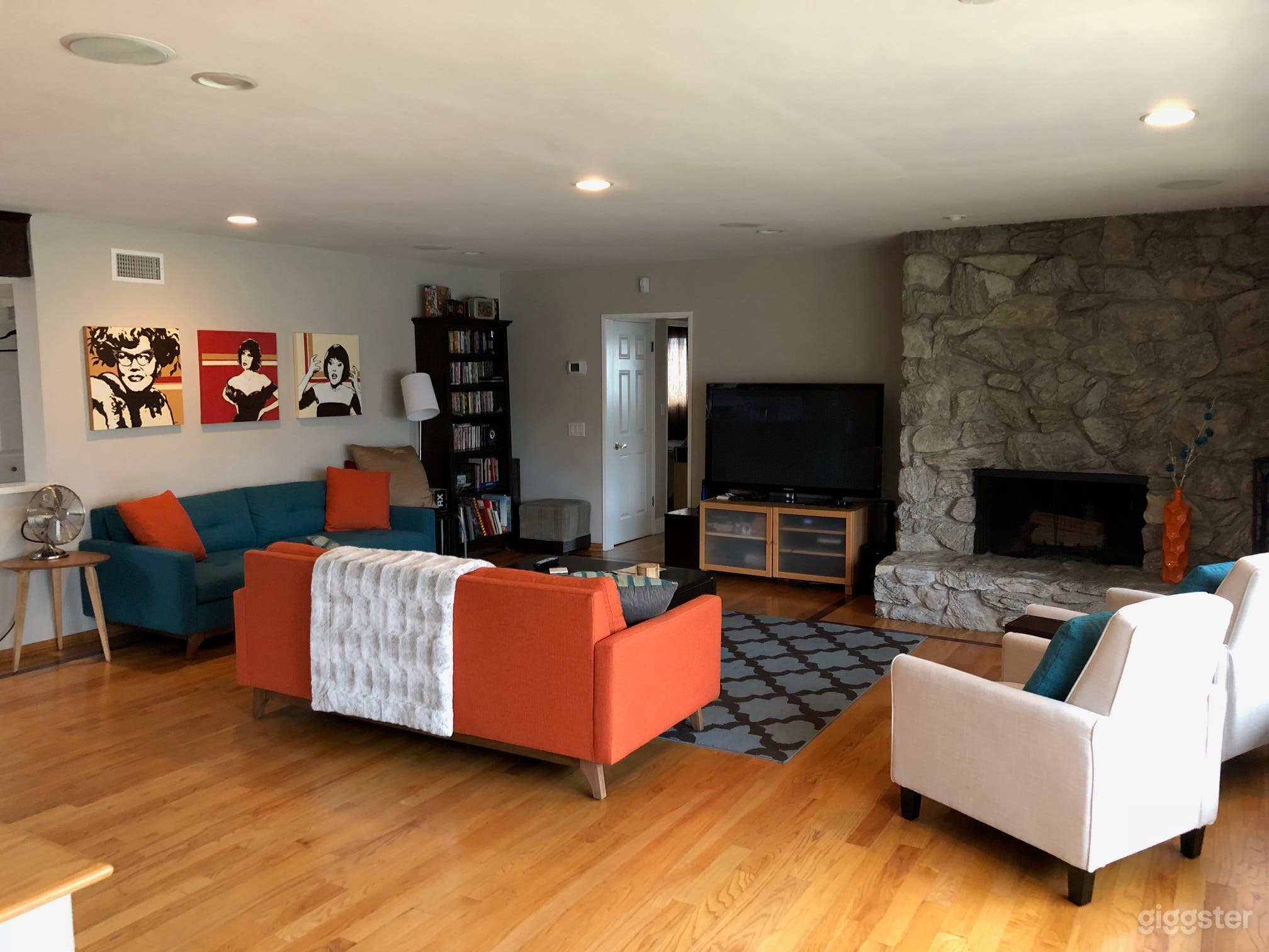 Colorful living room with large stone fireplace.