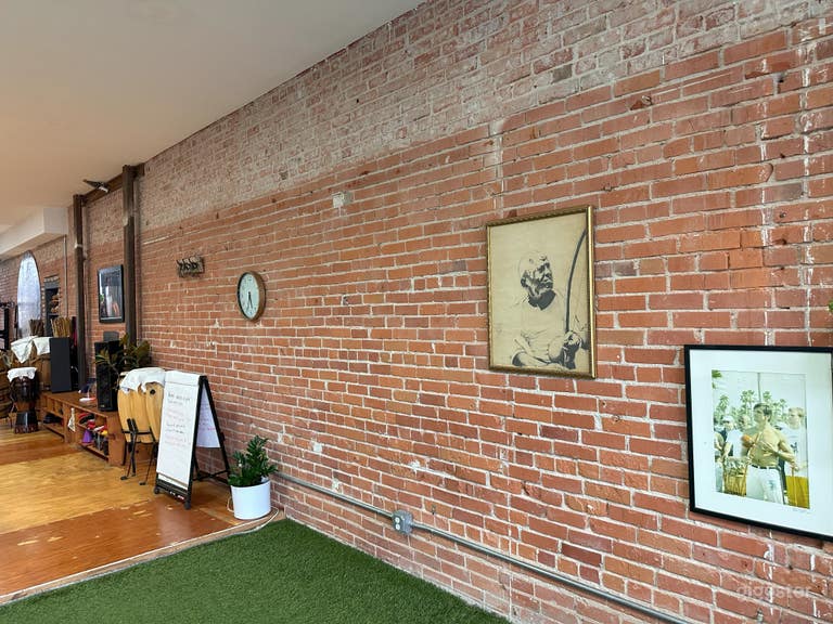 Exposed brick, steel beams and conduit. Clock and live plants 