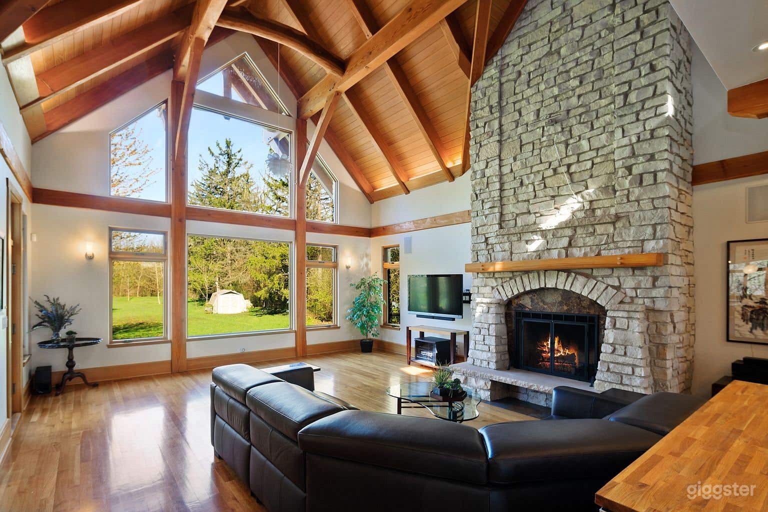 Main Residence Great Room with white oak radiant heated floors, stone and slate wood burning fireplace and vaulted, heavy timber ceiling with uplighting.