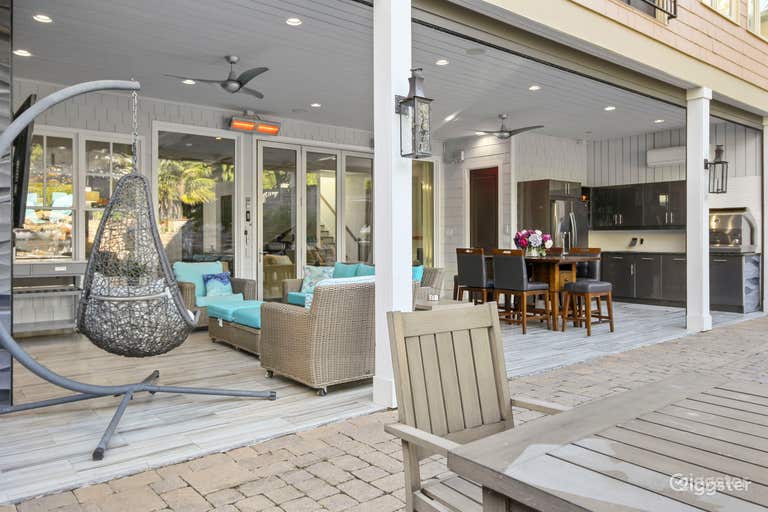  Sliding glass doors open from the house to the patio, which has an outdoor kitchen, ample seating and a bathroom 