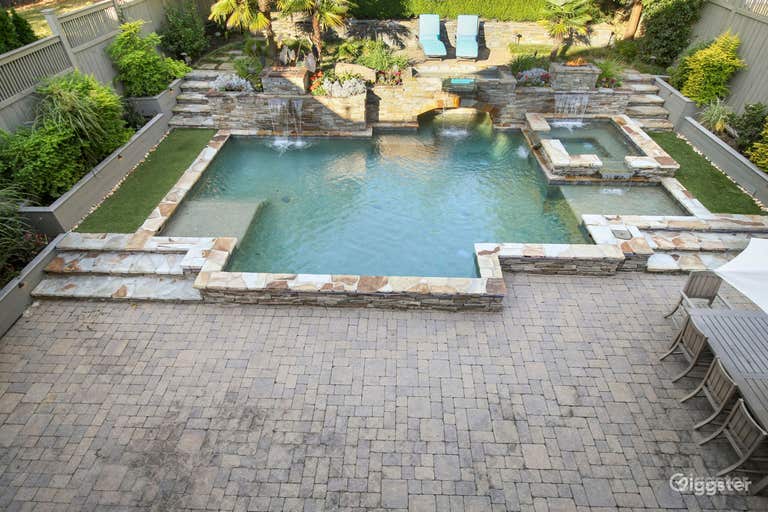  Saltwater pool encased in stone includes an inviting hot tub and two shallow side areas for lounging or swimming 