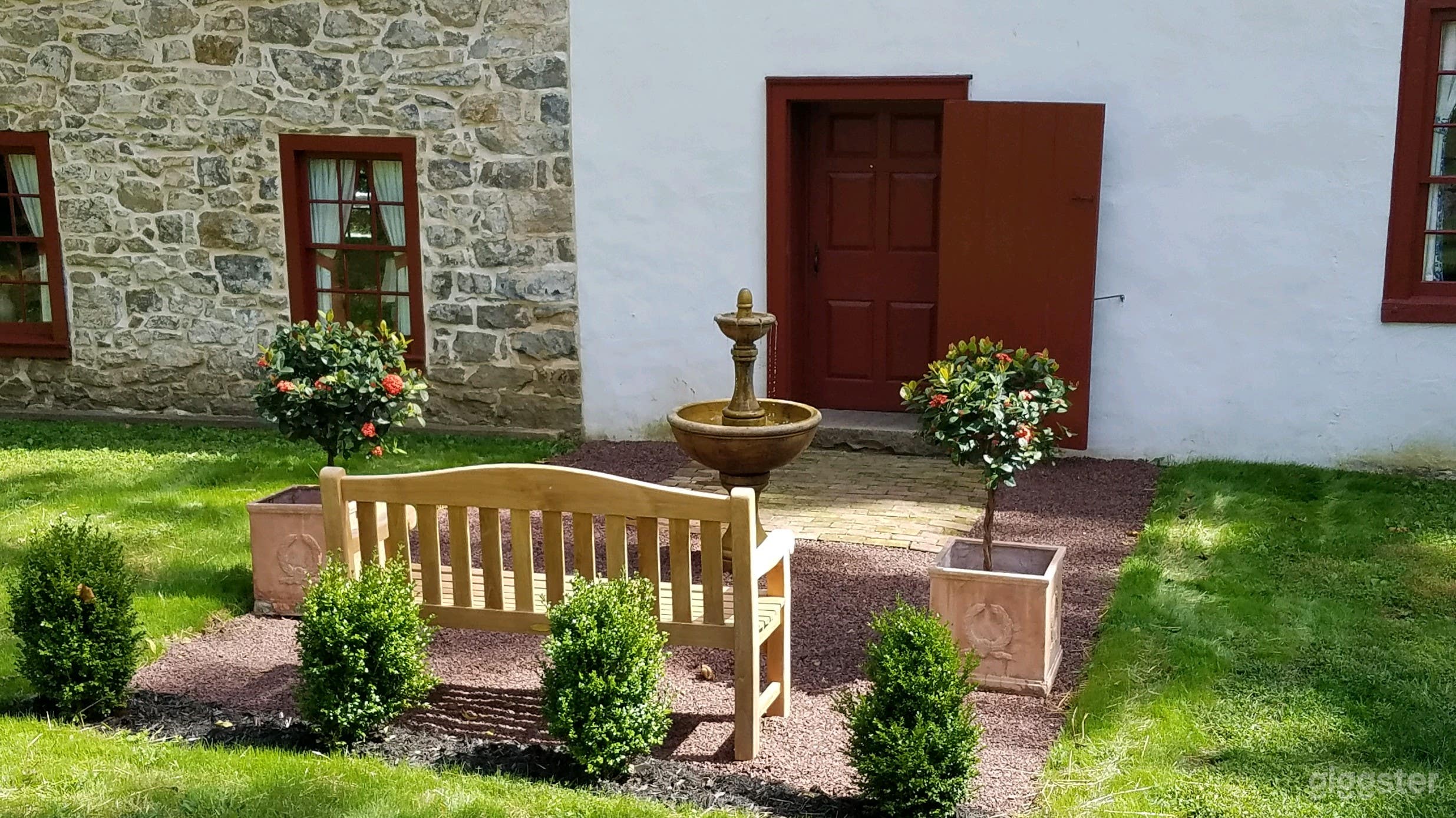 Summer scene highlighting small garden fountain detail at back of house