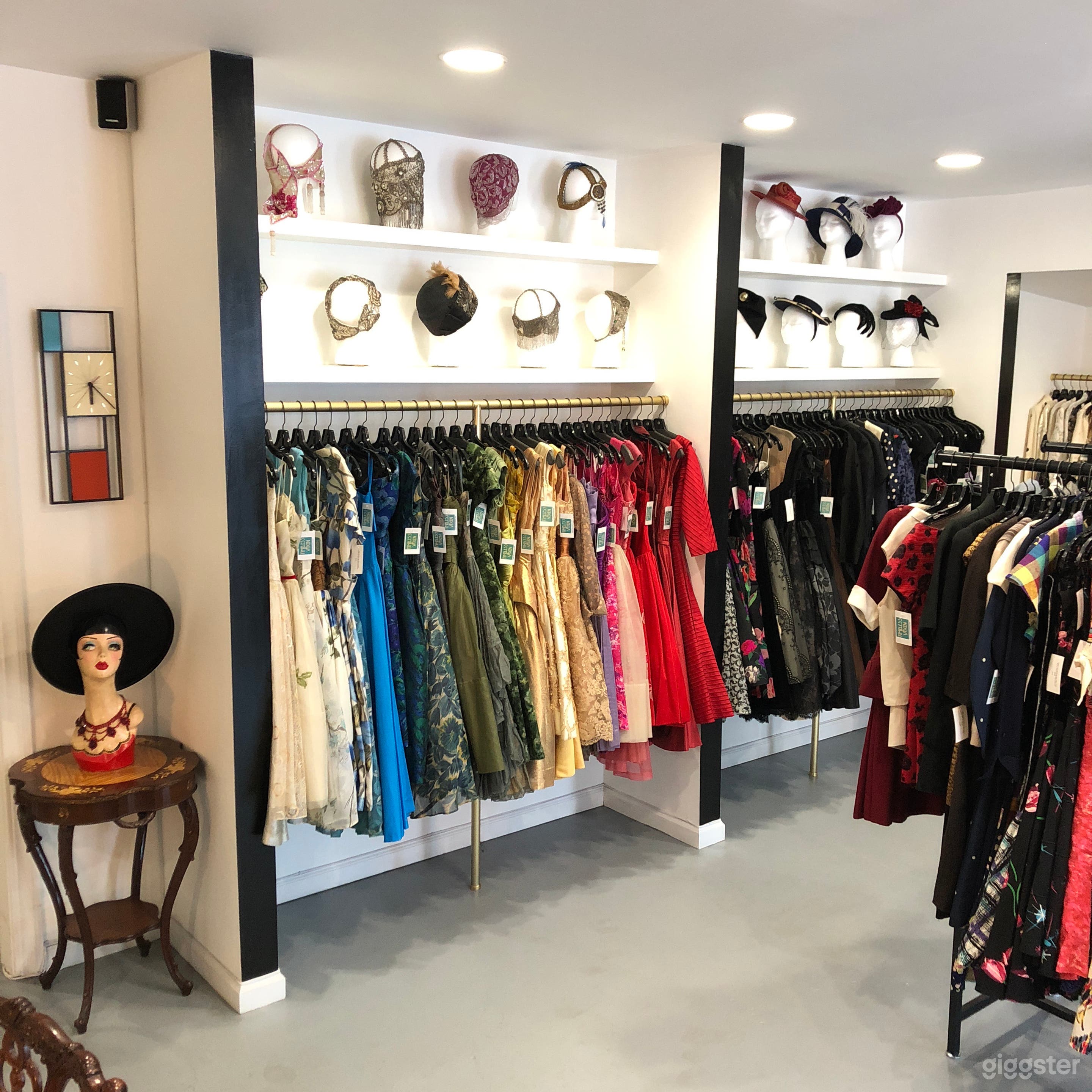 Wall of 50's party dresses, 20's headpieces and 40's hats