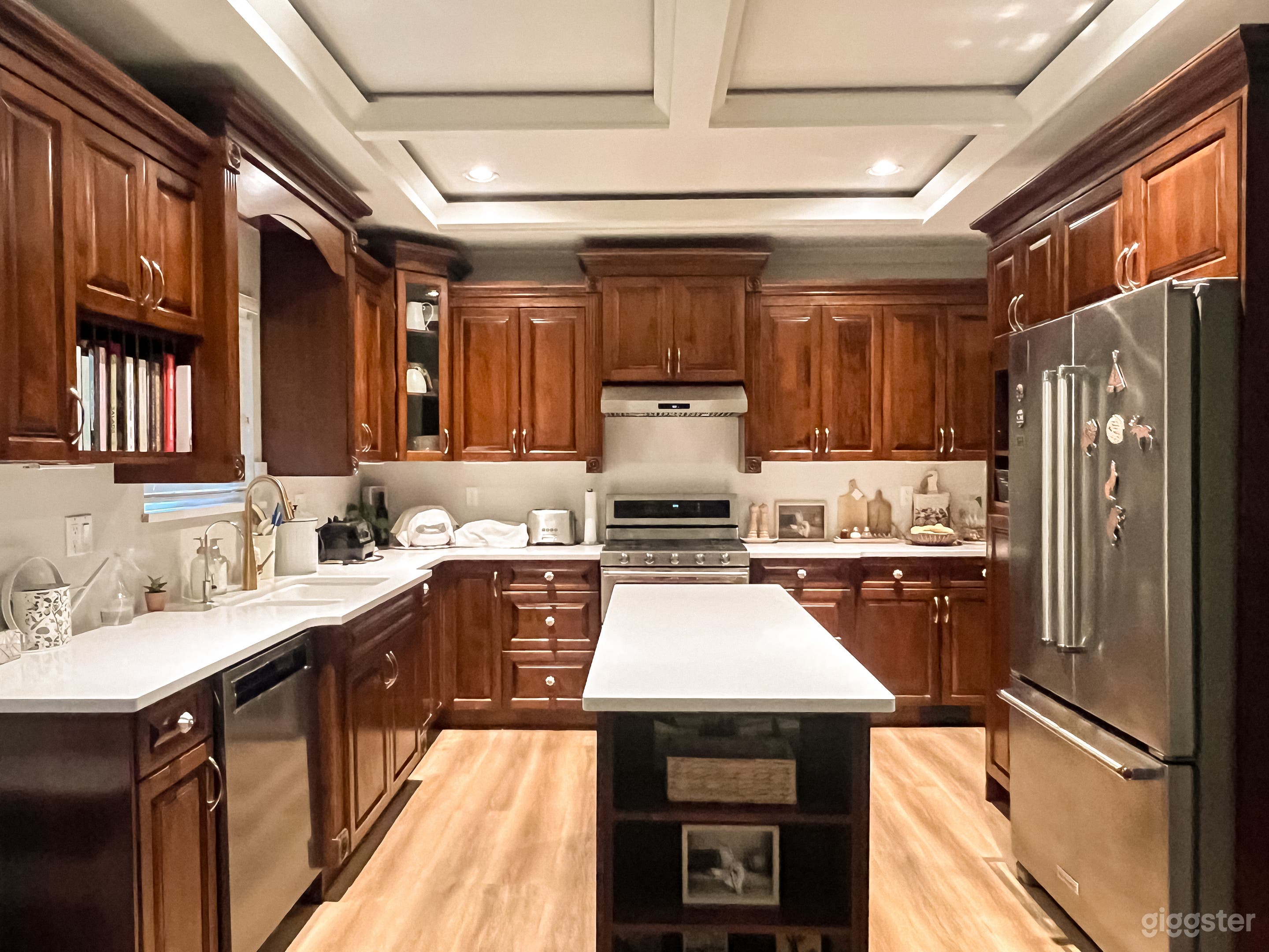Warm, classic kitchen with rich wood cabinetry, stainless steel appliances, and a bright central island.