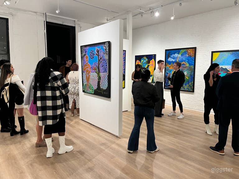  Guests explore a contemporary exhibition in a lively, inviting atmosphere. The gallery’s flowing layout encourages movement and interaction, making it an ideal space for openings and pop-up activations. 