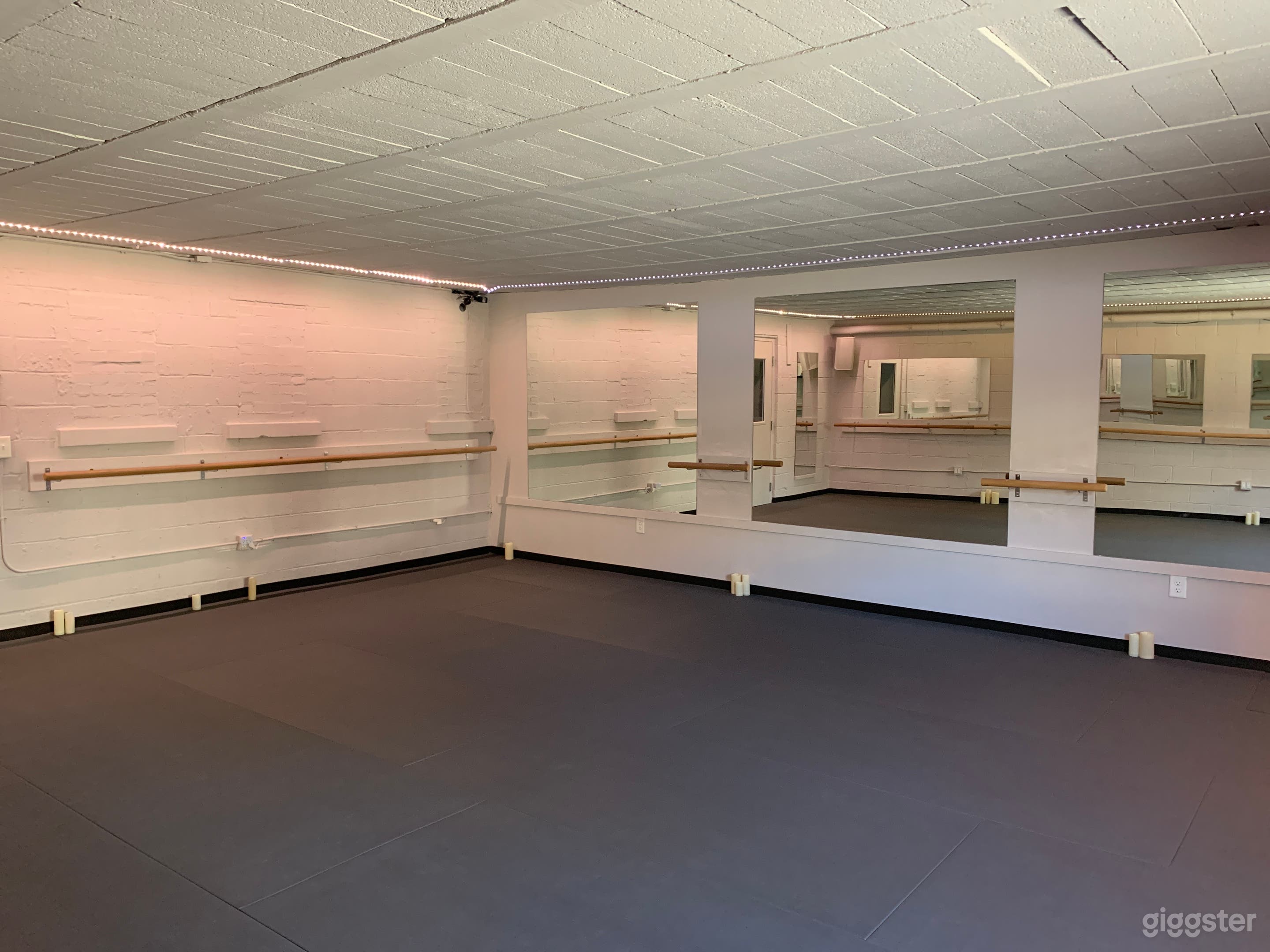 Barre room. Paded floor. Has door to the back lot. Mirrored on three walls. 