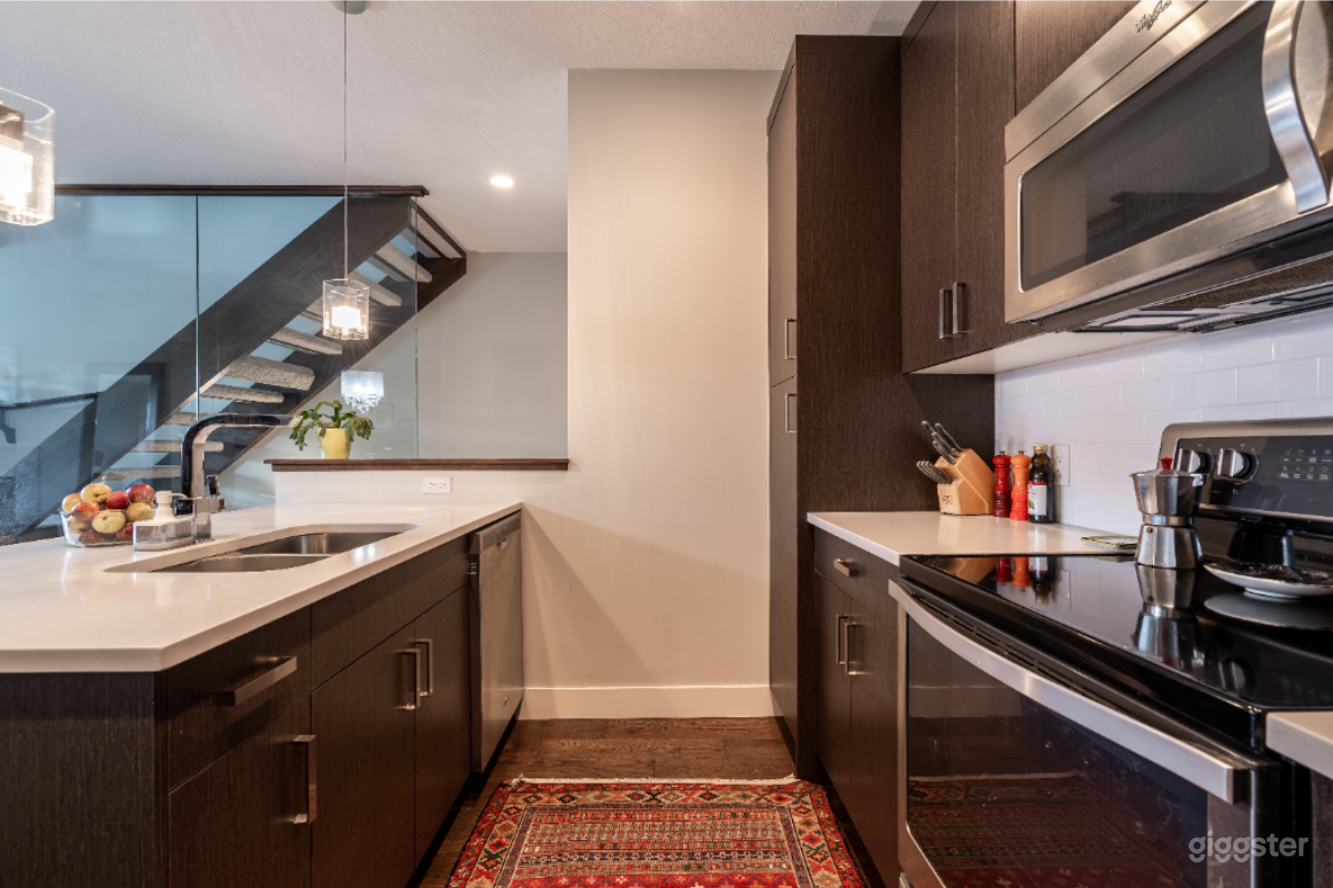 Kitchen with view of glass wall and open staircase.
