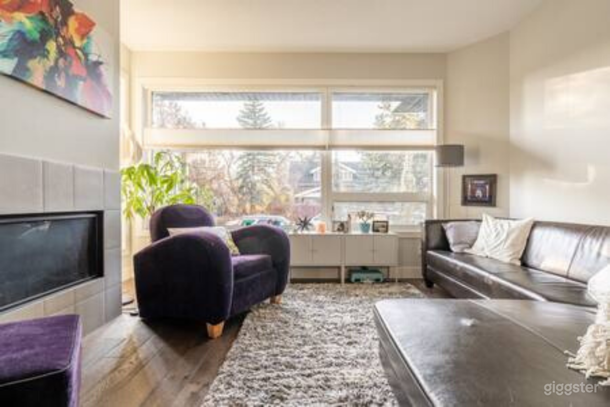 West facing living room with massive windows, fireplace, contemporary decor.