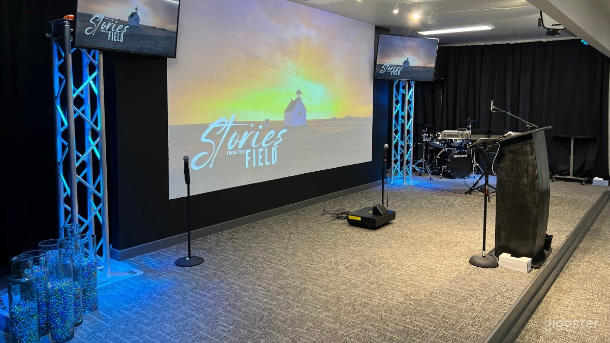 Stage with 2 TV screens and a large wall-projector.