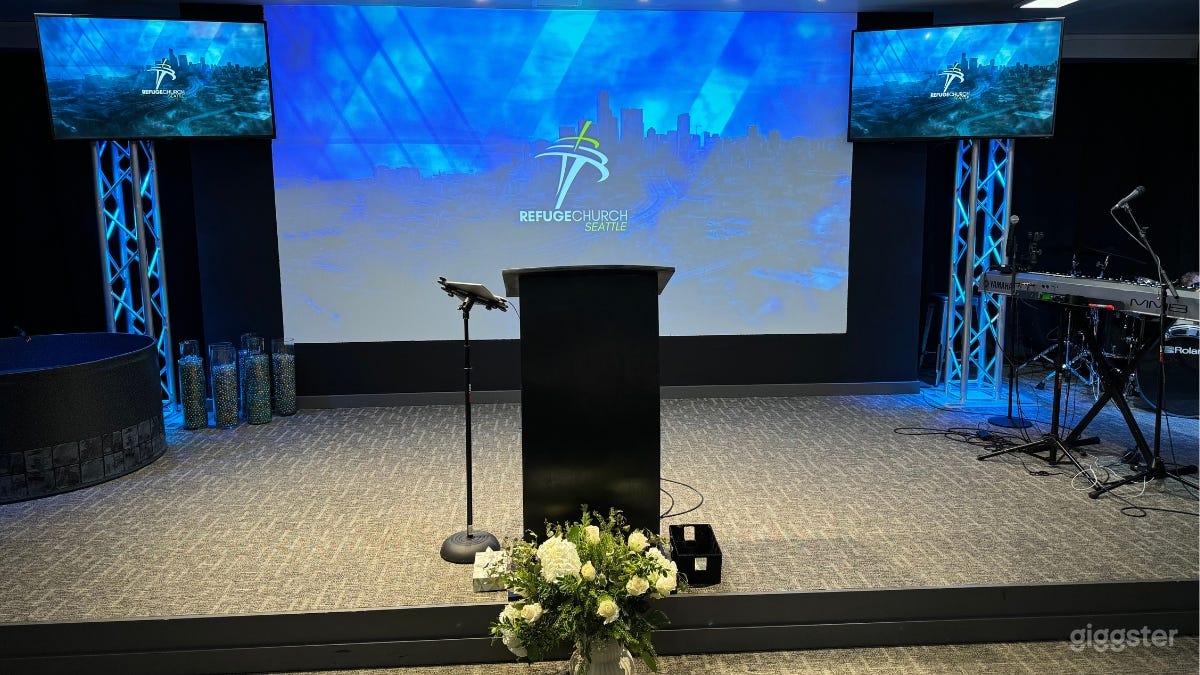 Stage with 2 TV screens and a large wall-projector.