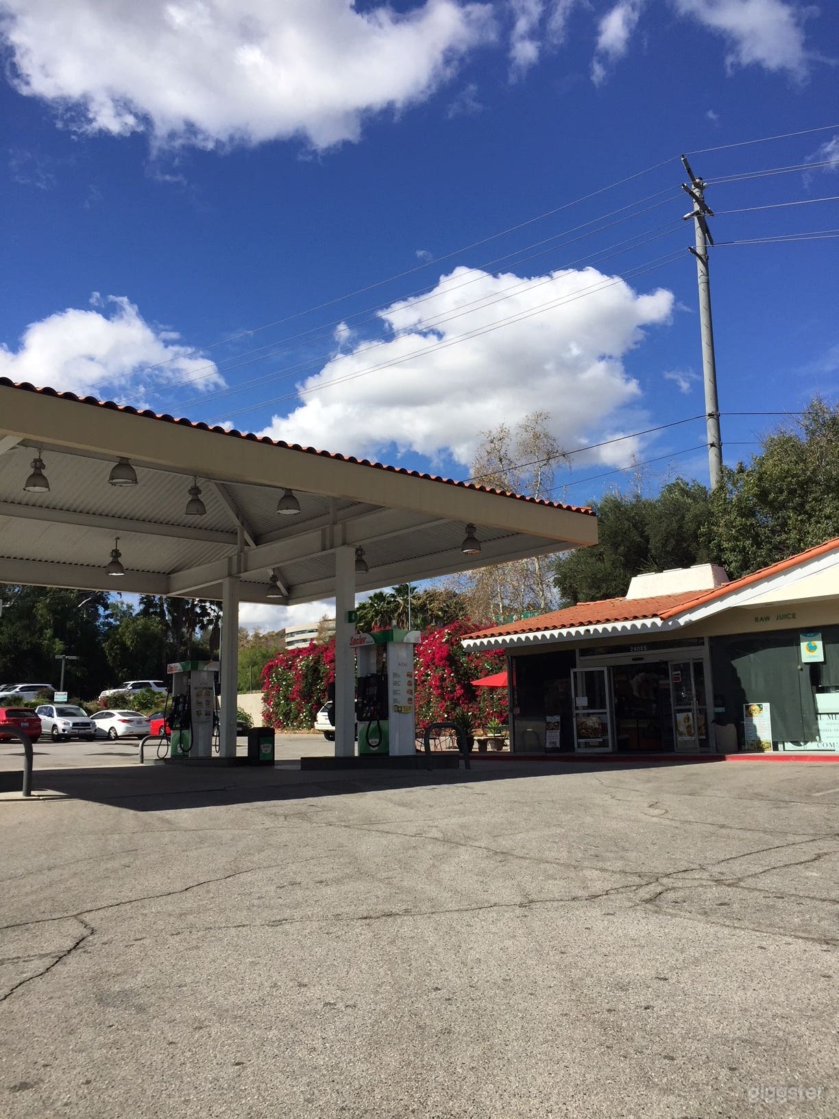 Gas pumps and front of mini mart, Blimpie Subs, Coffee, El Charro Mexican Food inside Gas Station. 