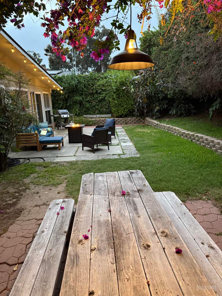  Jardín trasero exuberante con muebles, luces, mesa de picnic 