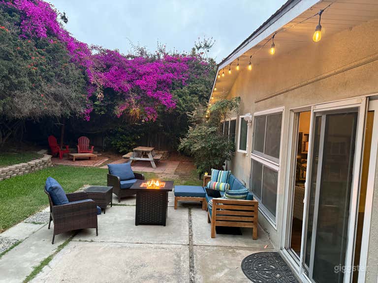  Jardín trasero exuberante con muebles, luces, mesa de picnic 