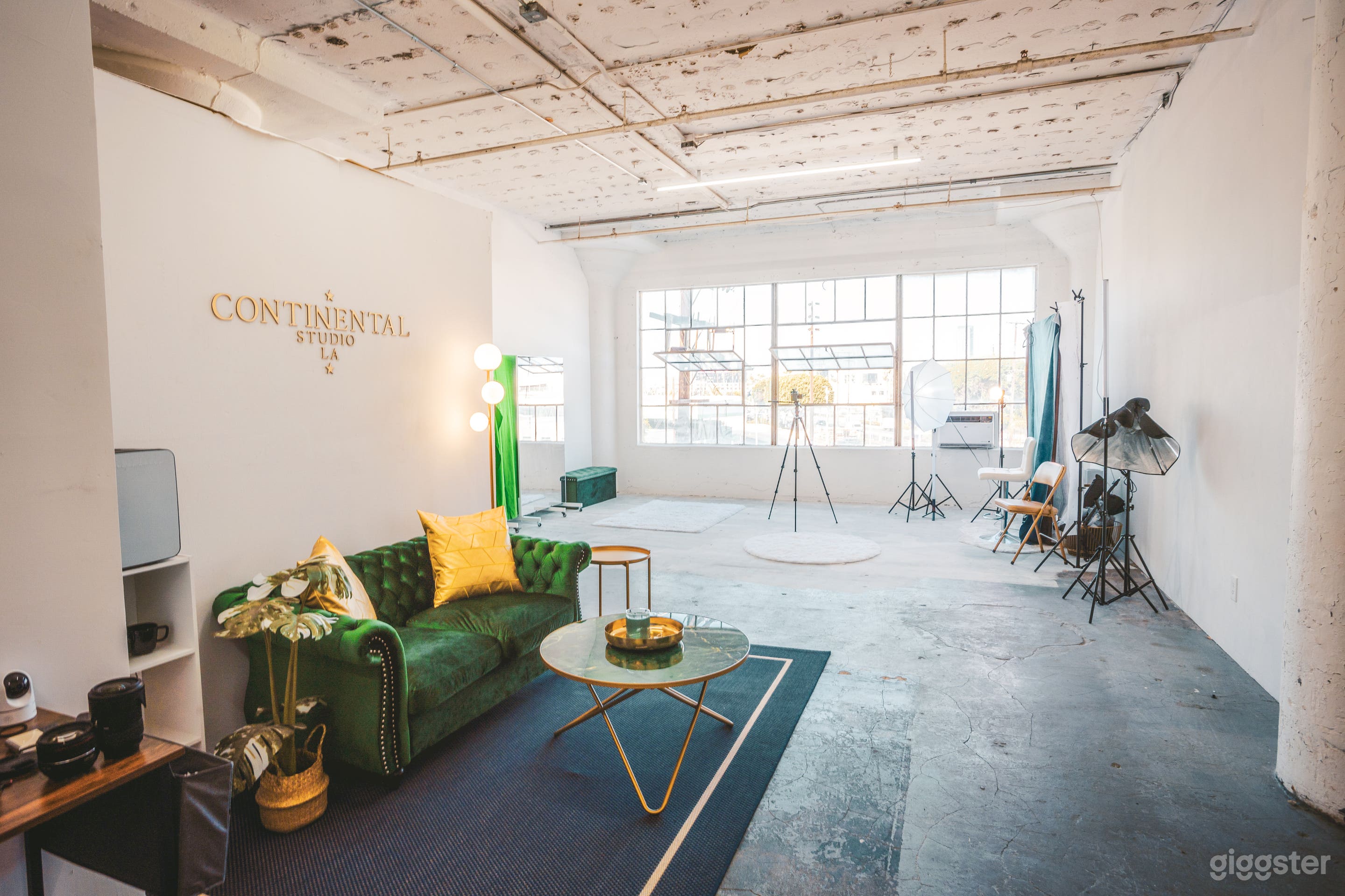 Green Room, with coffee table, sofa, work desk, chairs, a mini fridge.