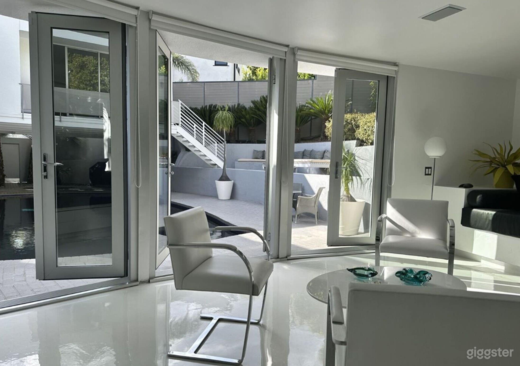 Light and bright cabana with comfortable pool friendly seating looks out to pool and lounging areas.