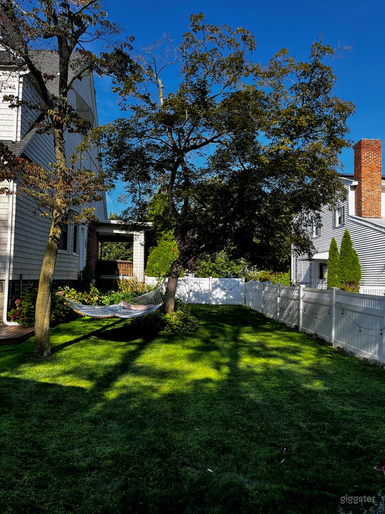  Backyard, facing toward the street. The yard is fully fenced in. Beautiful shade tree provides backdrop and a cooler area if filming or gathering outdoors.  