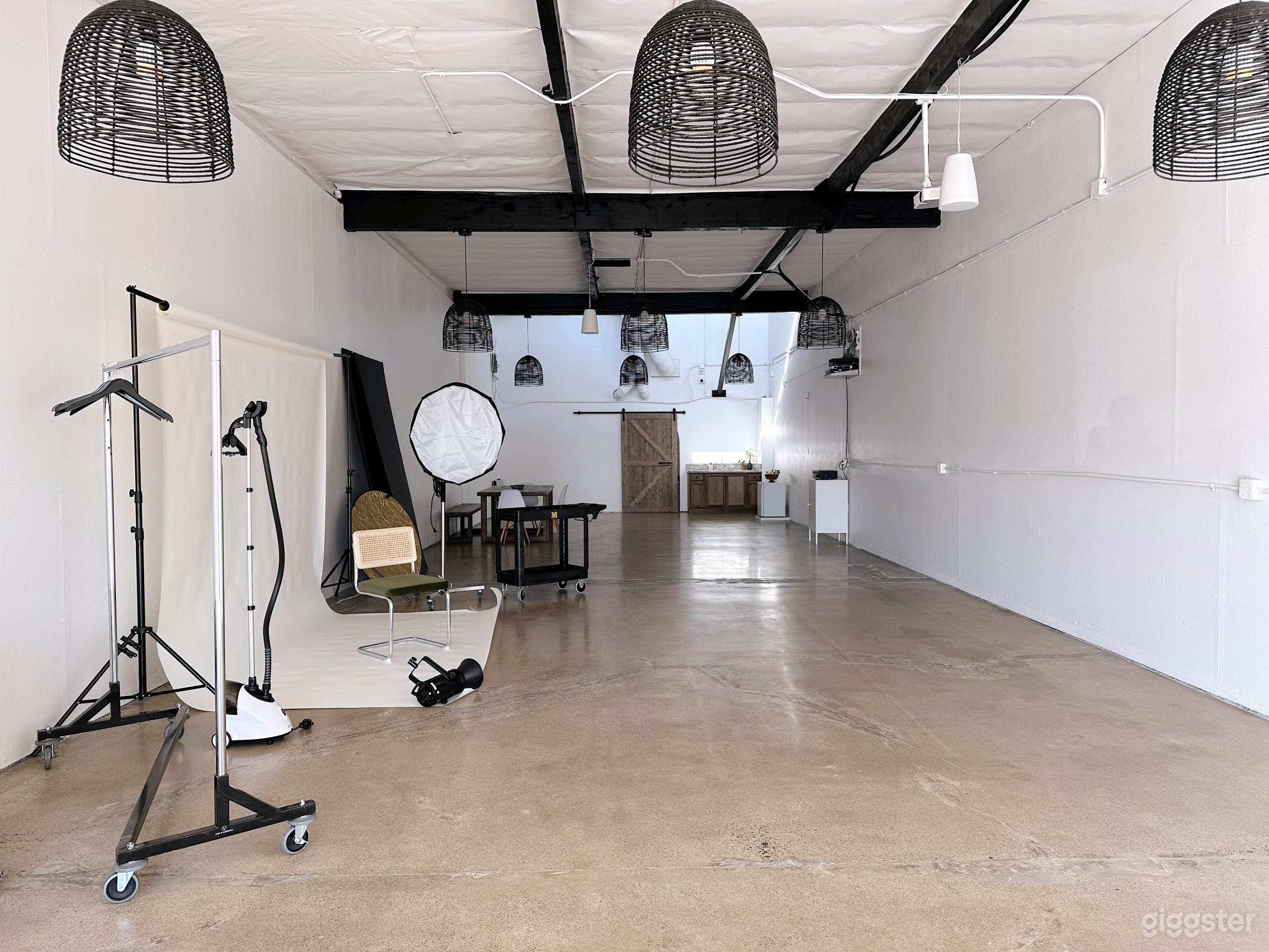 WAREHOUSE STUDIO: Large warehouse features polished concrete floors, white walls, tall ceilings, cage pendant lights, bluetooth-activated speakers