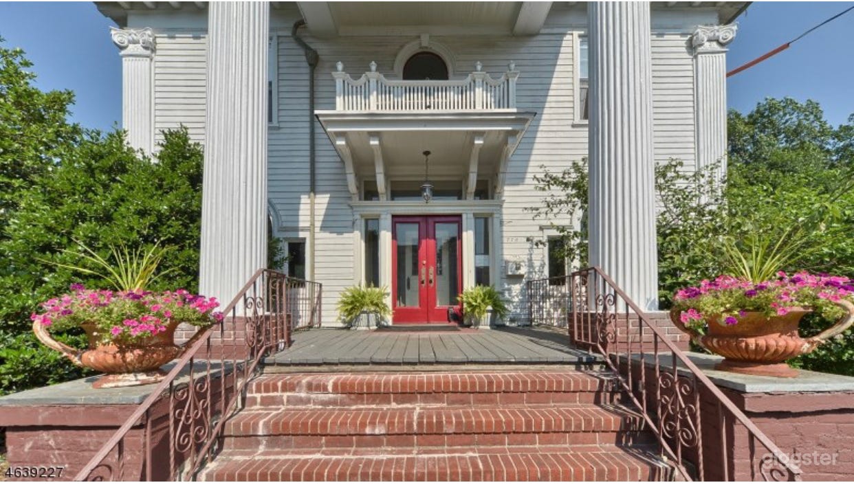 Grand Portico Entrance flanked by 2 Colossal Corinthian Columns 