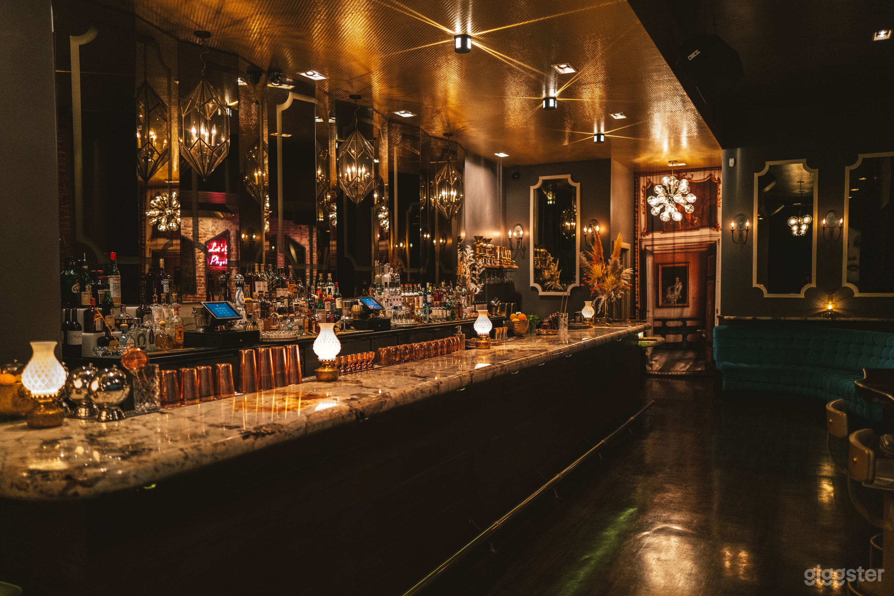 Main Bar space, crystal bar top, Bronze mirror back bar, quilted gold ceiling covering with starlights. Vintage oil lanterns with quilted milk glass chimneys.