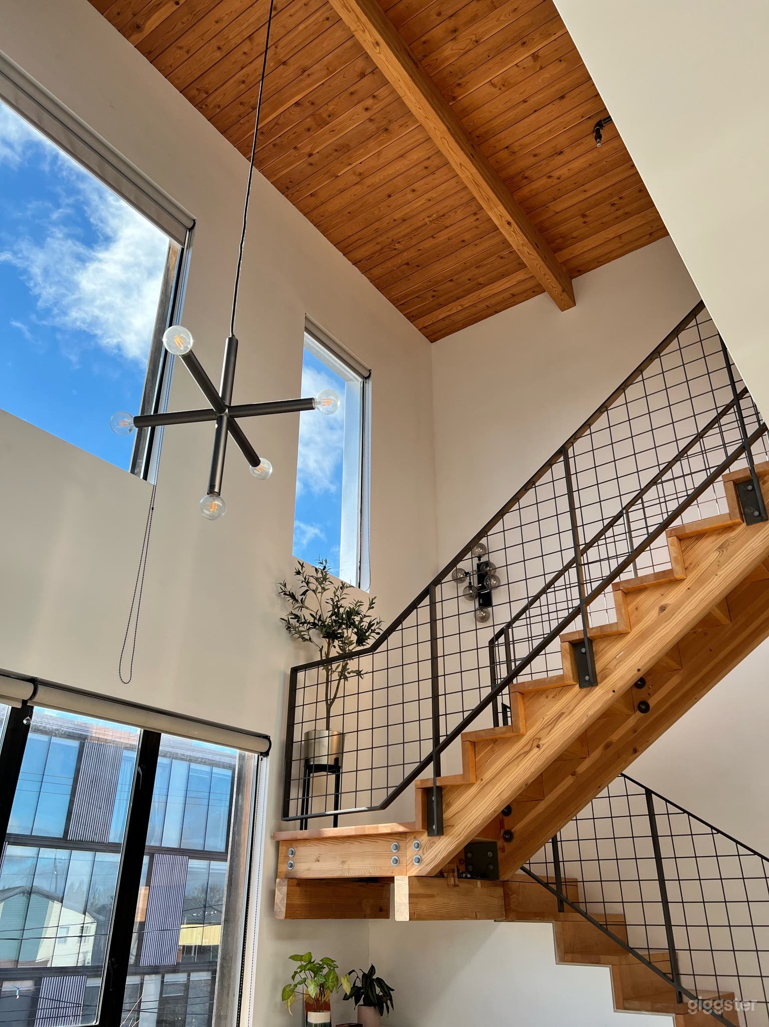Main room with staircase, kitchen, and livable space. East and South facing windows.