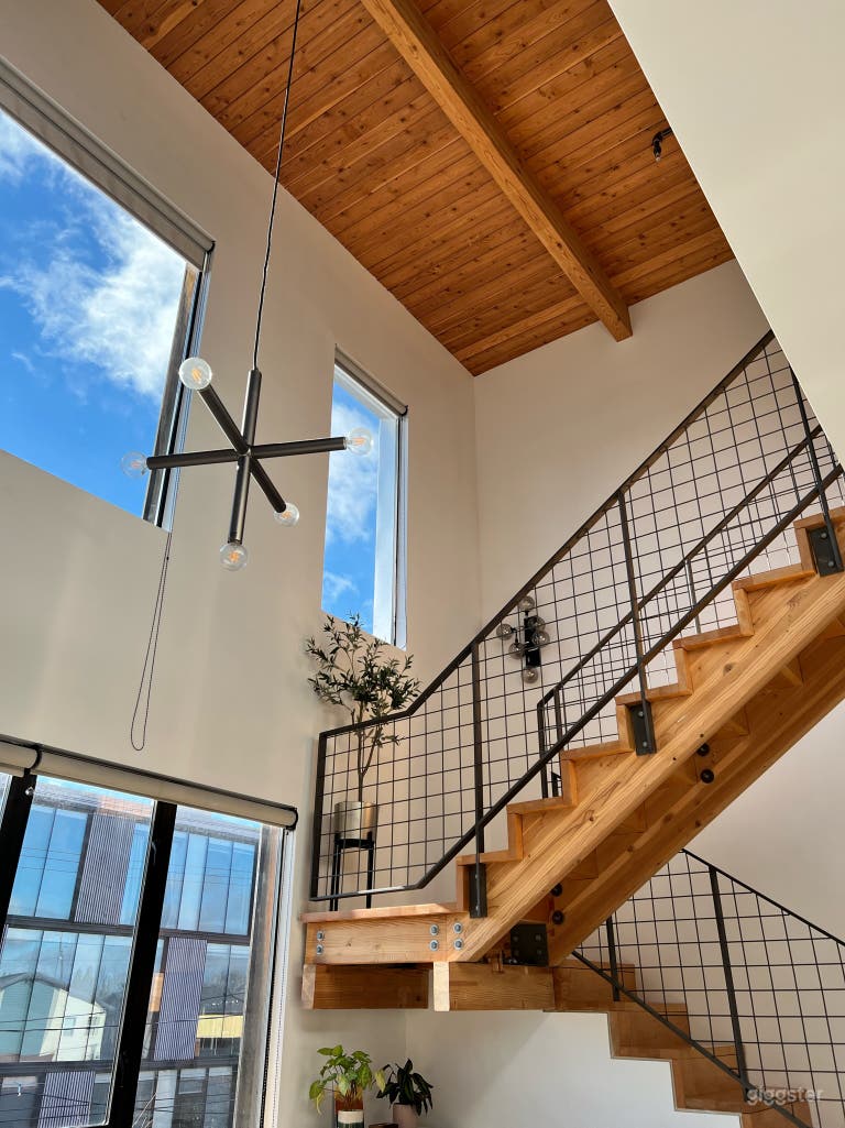  Main room with staircase, kitchen, and livable space. East and South facing windows. 