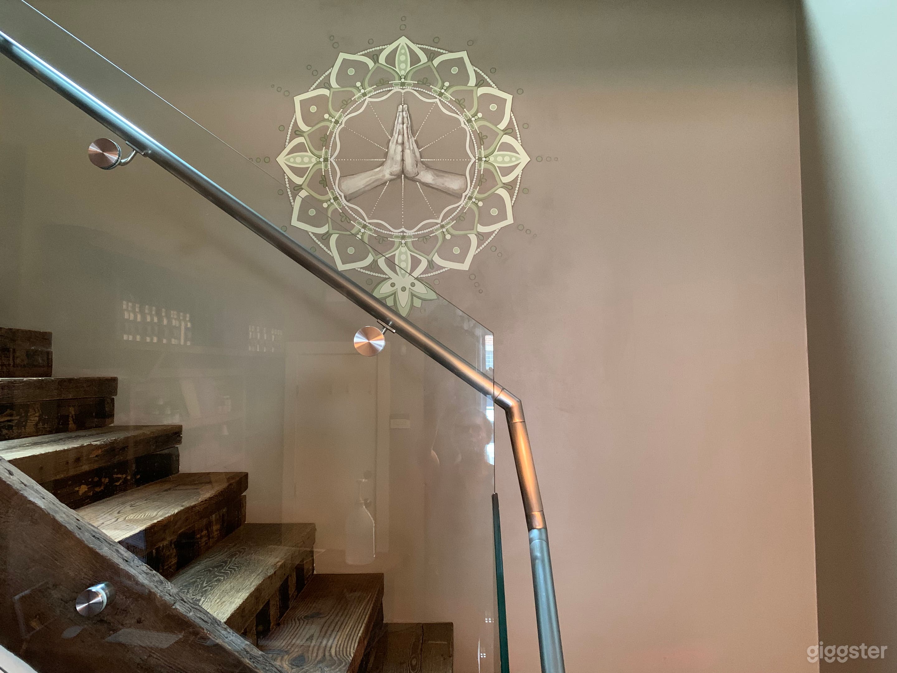 custom mandala mural in lobby with reclaimed wood stairs heading to 2nd floor studio spaces