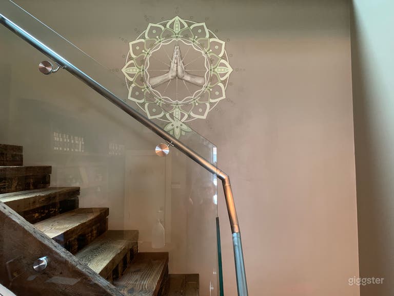  custom mandala mural in lobby with reclaimed wood stairs heading to 2nd floor studio spaces 