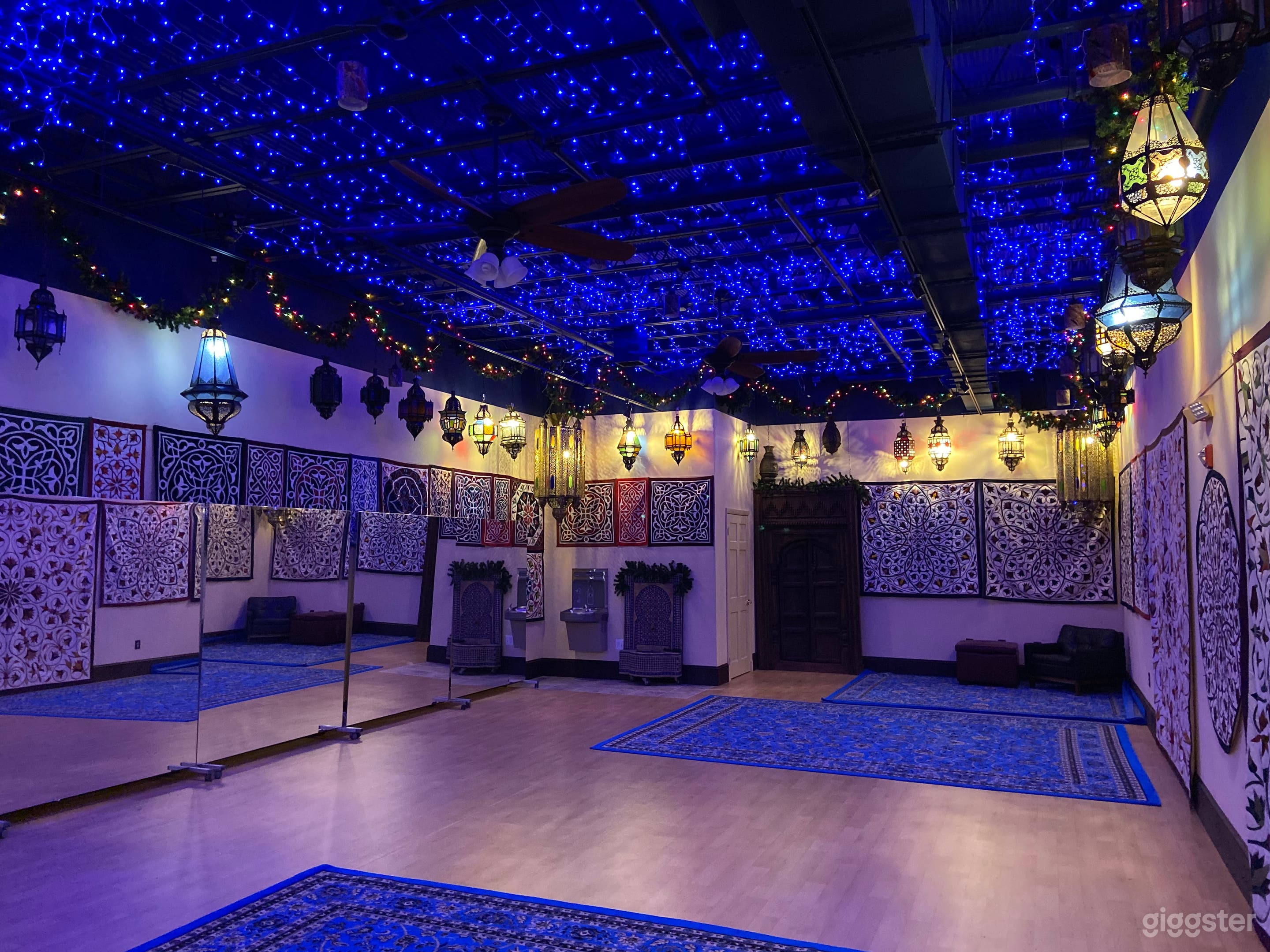 Blue ambient ceiling lighting on a separate switch. Mirrors are on rollers and can be removed. Tapestries can be removed. Turquoise and black rugs to cover the dance floor can be laid down or removed. Studio is 1000 sq ft.