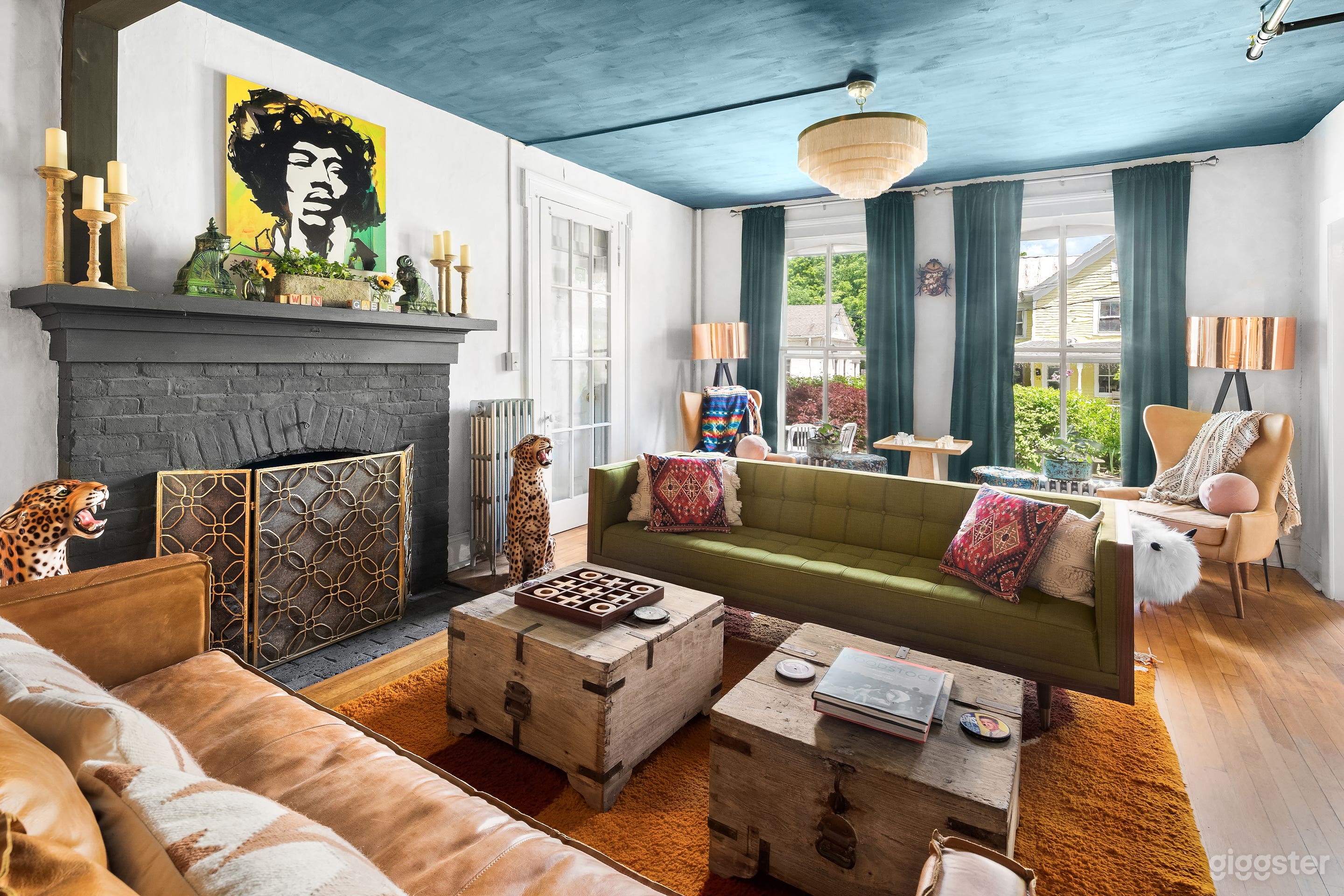 Parlor off the entryway with lounge area, chess table and arm chairs, record player and beanbag chairs, gas fireplace 