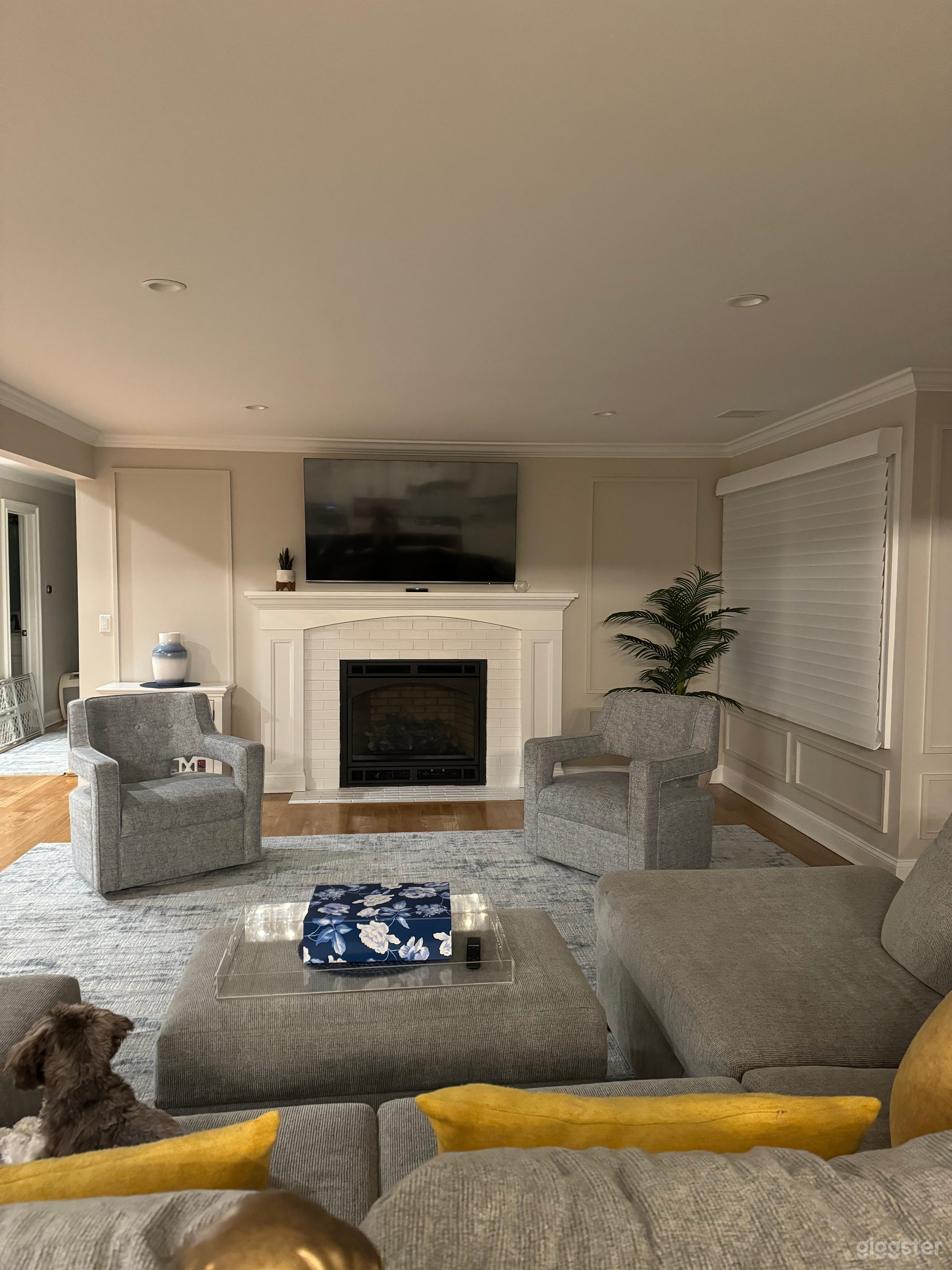 Spacious living room with wood flooring, area rugs, and fireplace.