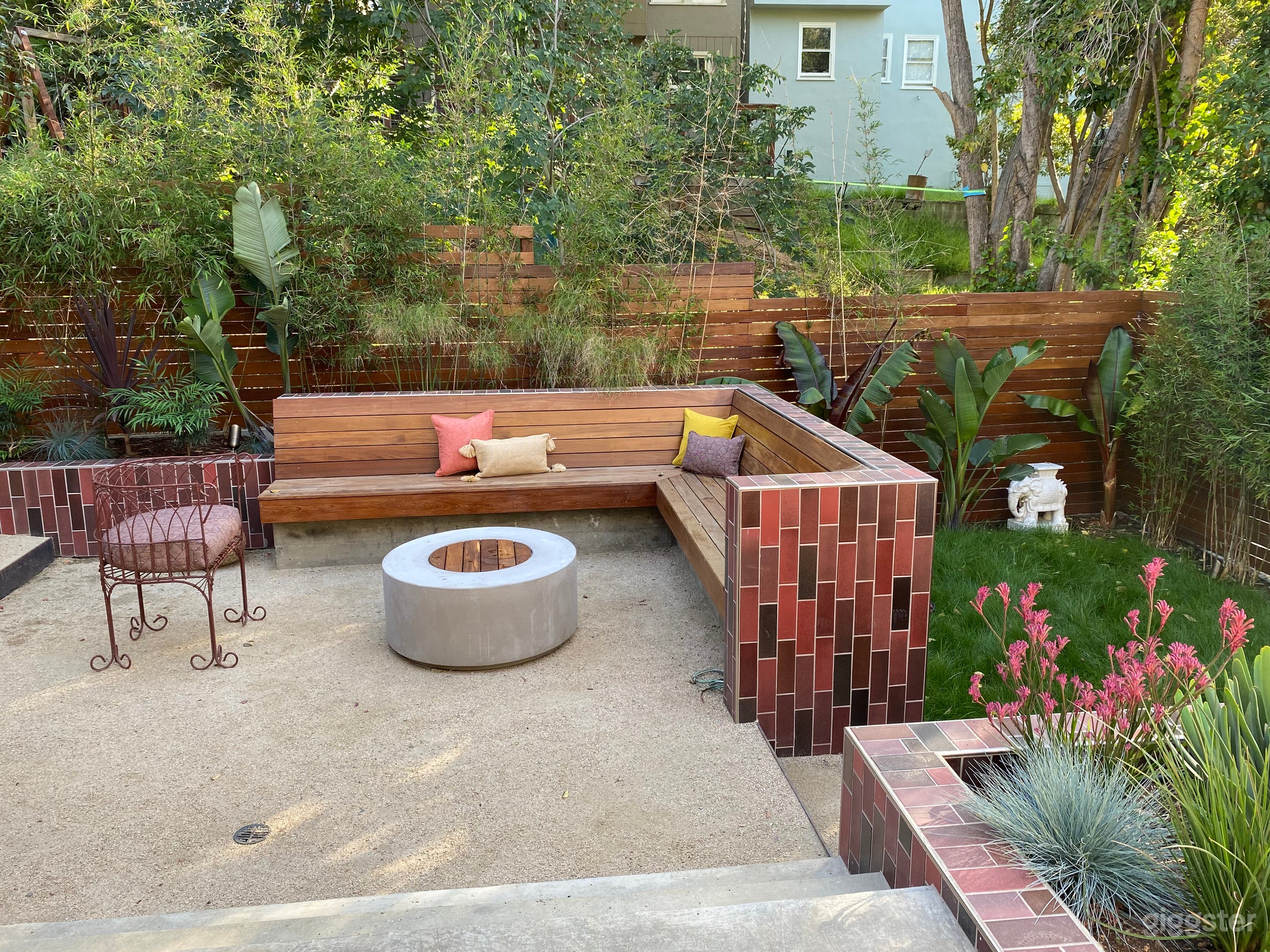 Unique, colorful backyard with terraced spaces, Heath tile, lush tropical plants, fire pit. 