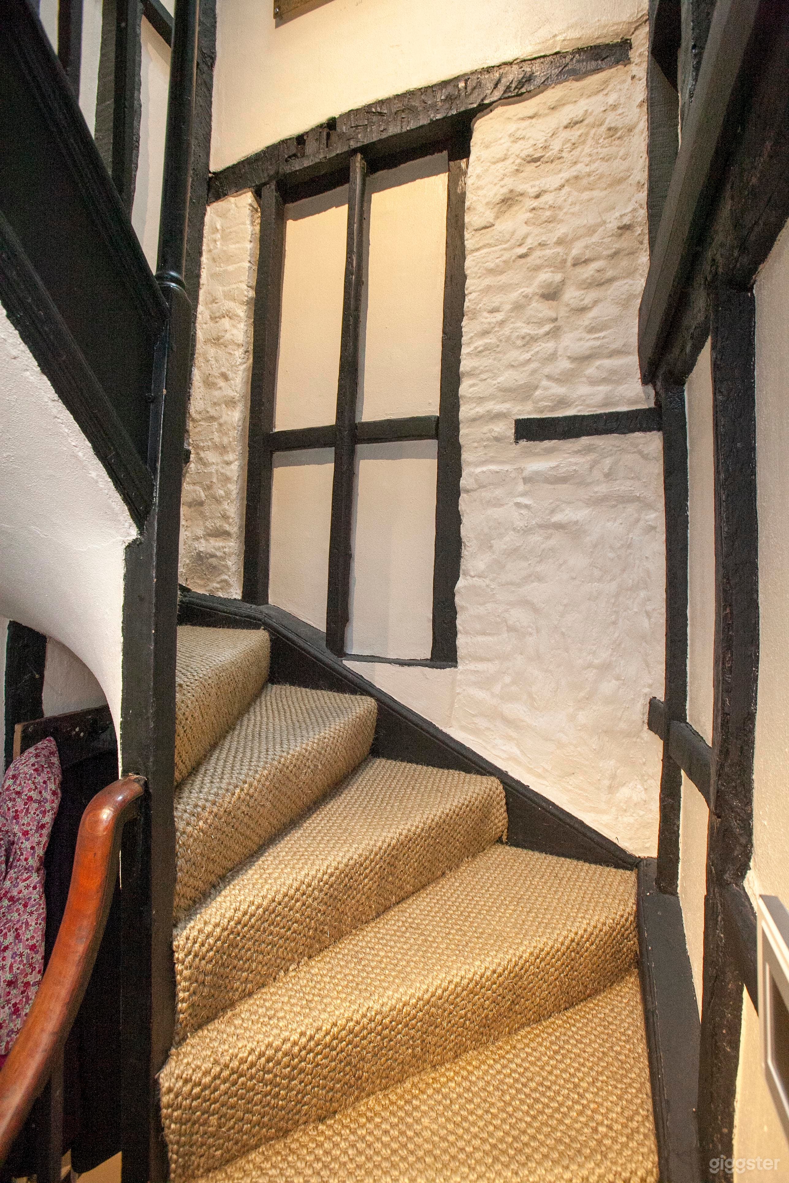 Spiral stairs with original exposed brick wall and beam features