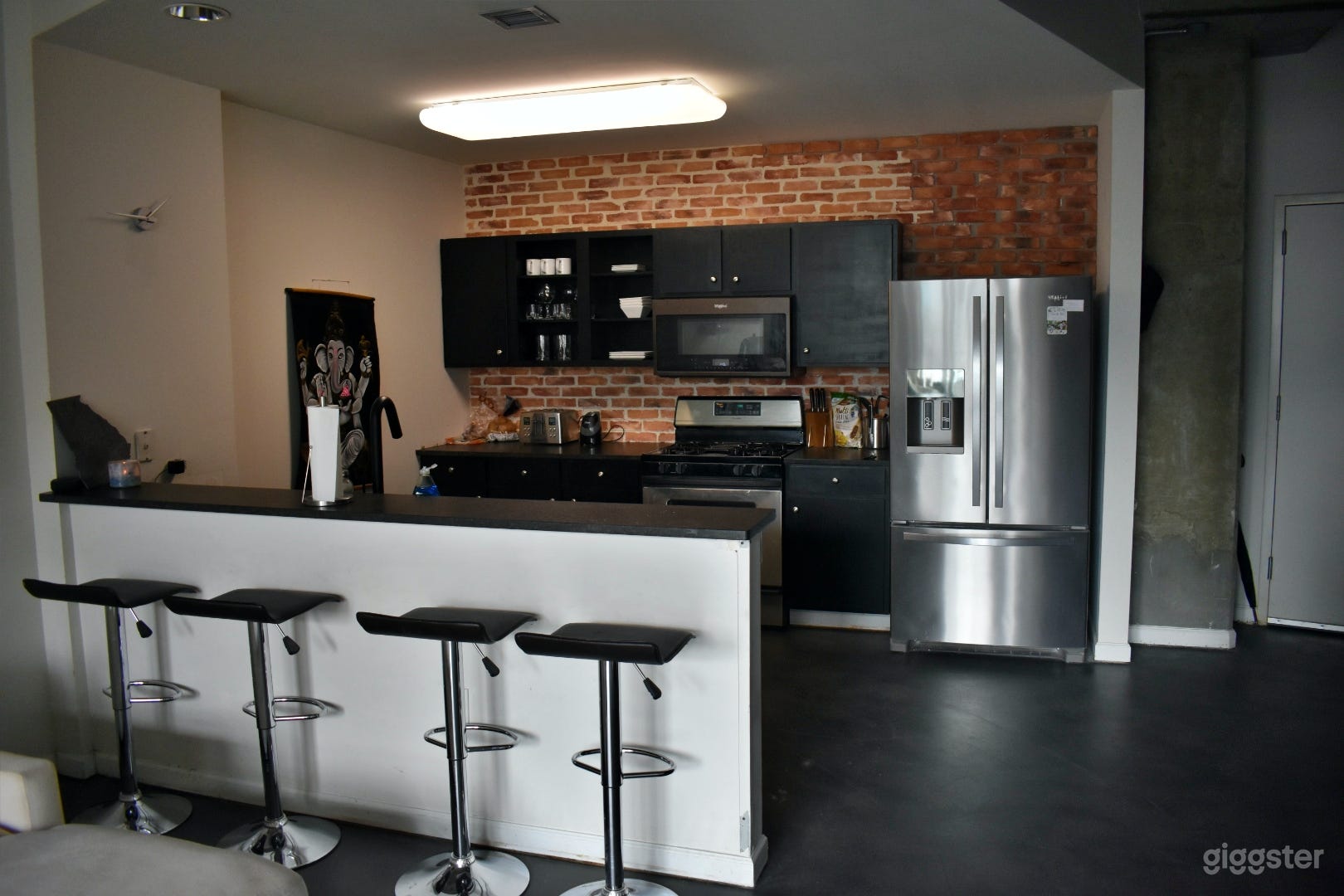 Newly renovated kitchen with real brick wall and custom granite counters