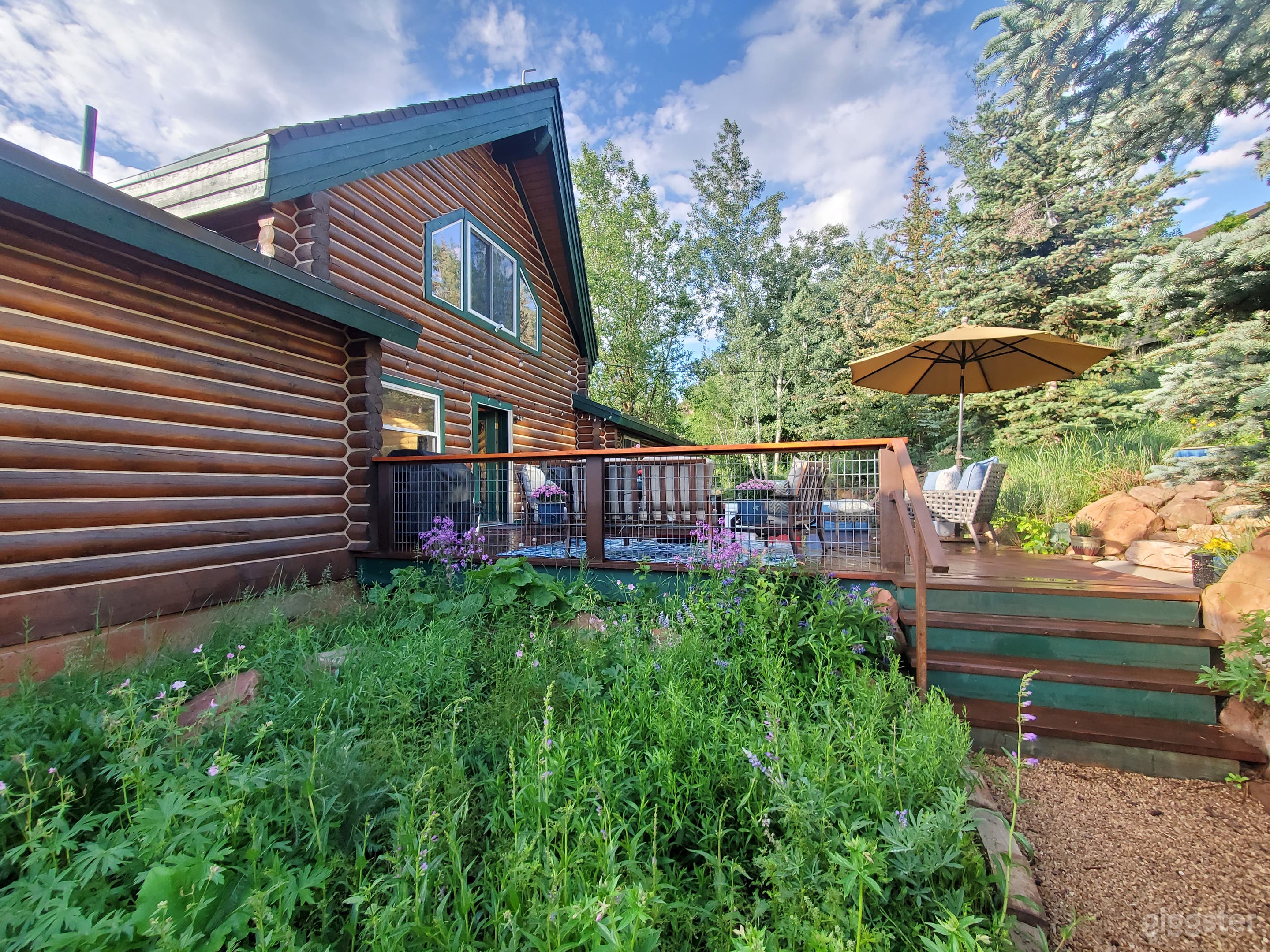 Log home back yard in Park City with elevated deck and furnishings, hot tub, fire pit in a step-up elevated area grills
