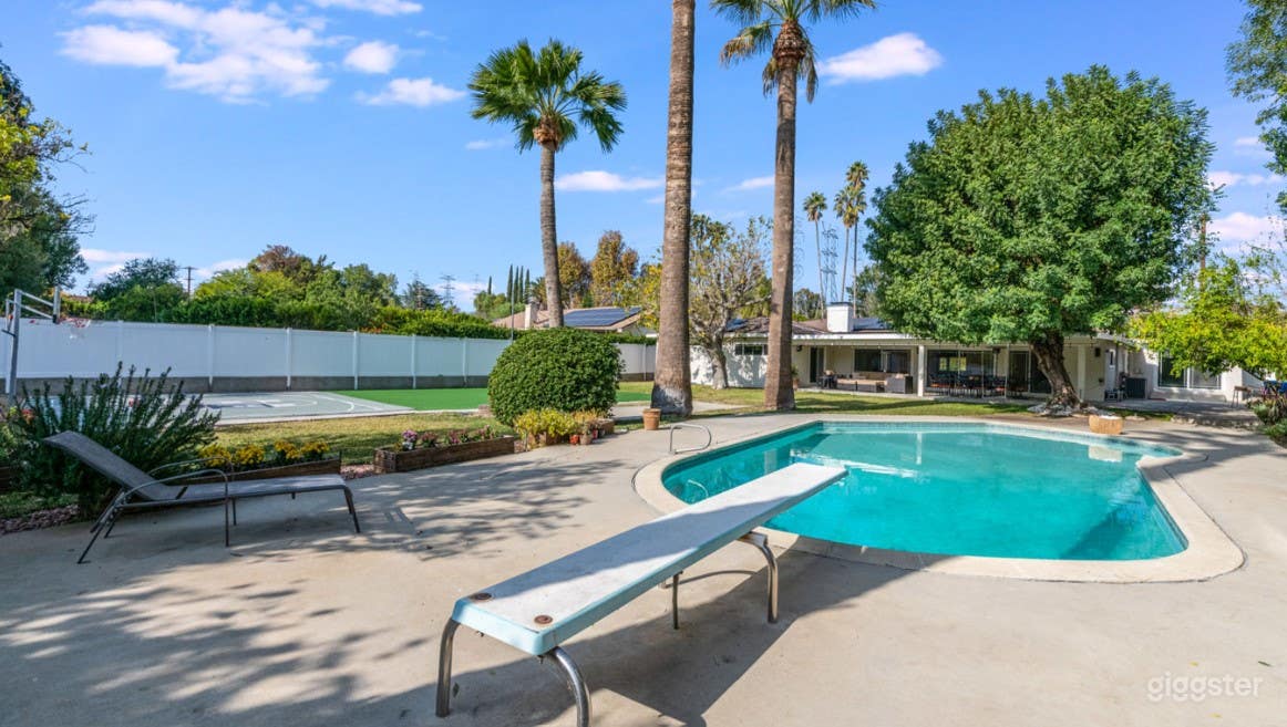 Classic Backyard Pool with Diving Board  Photo 1