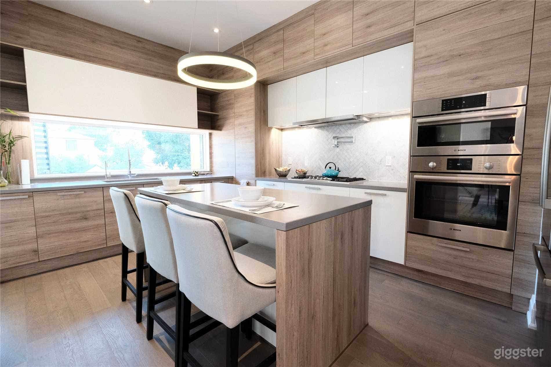 Chef's kitchen with modern appliances. Please note the chairs are now grey cloth bar stools.