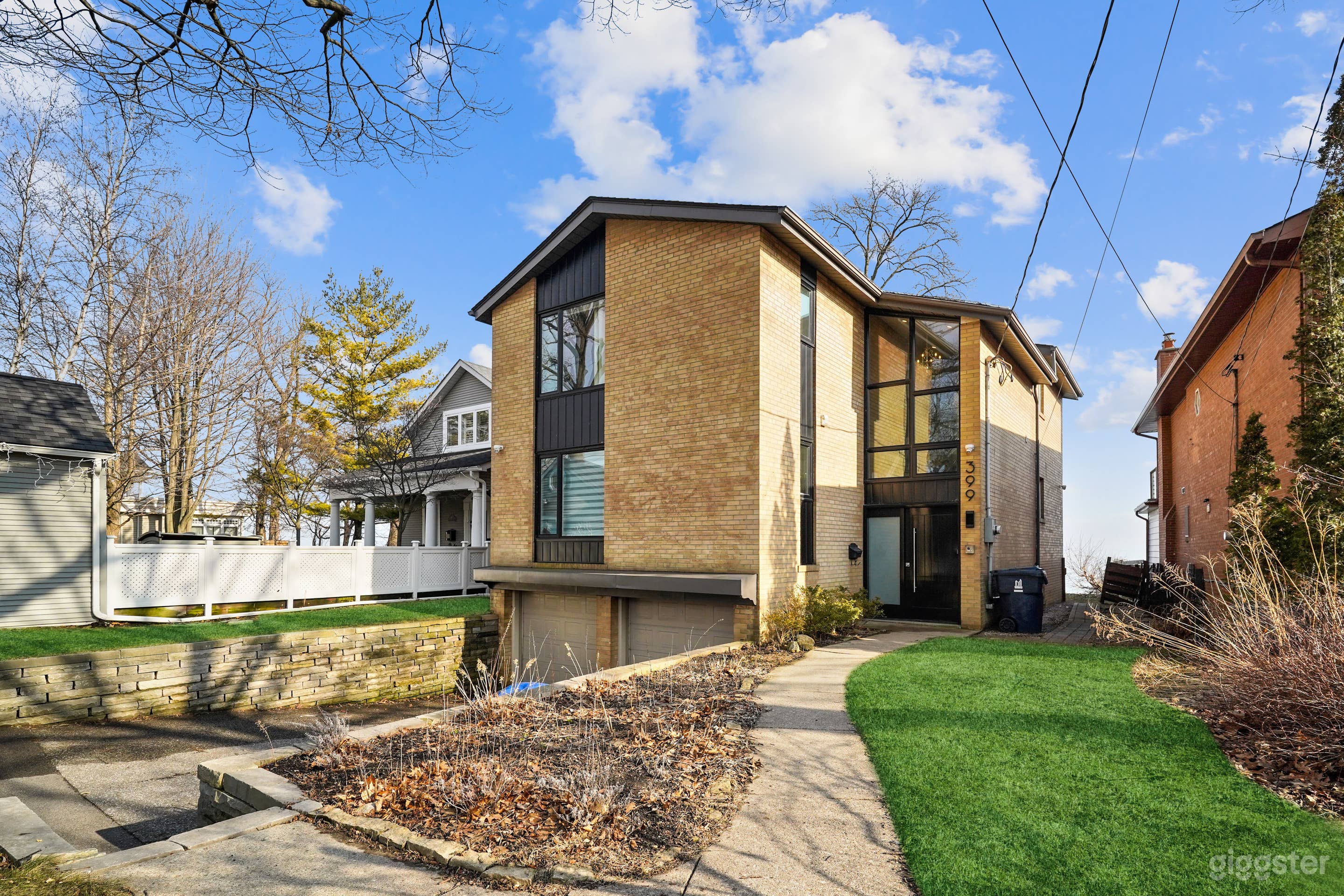 Front of 2-storey lakfront house (garage doors are now painted black)