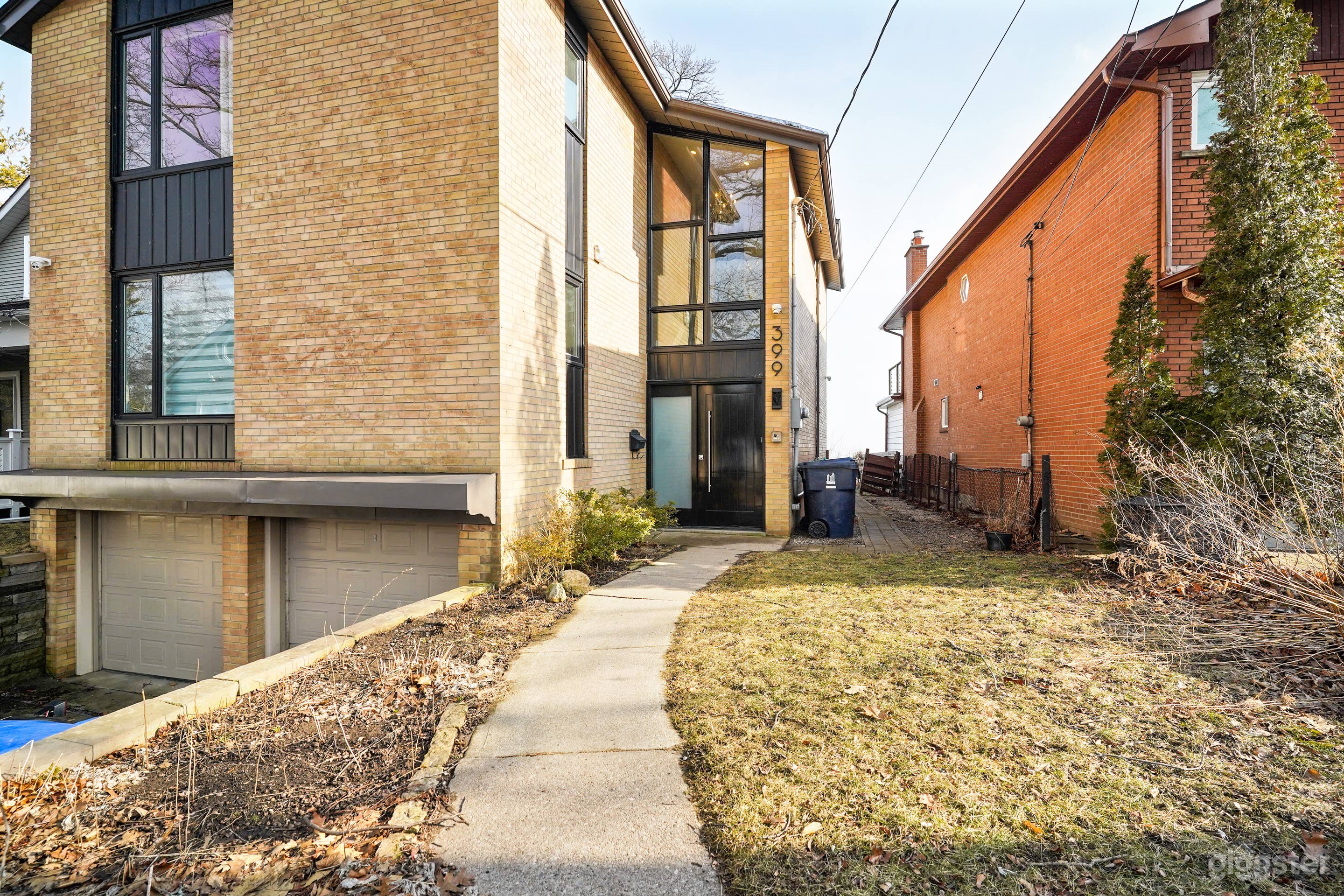 Front of 2-storey lakfront house (garage doors are now painted black)