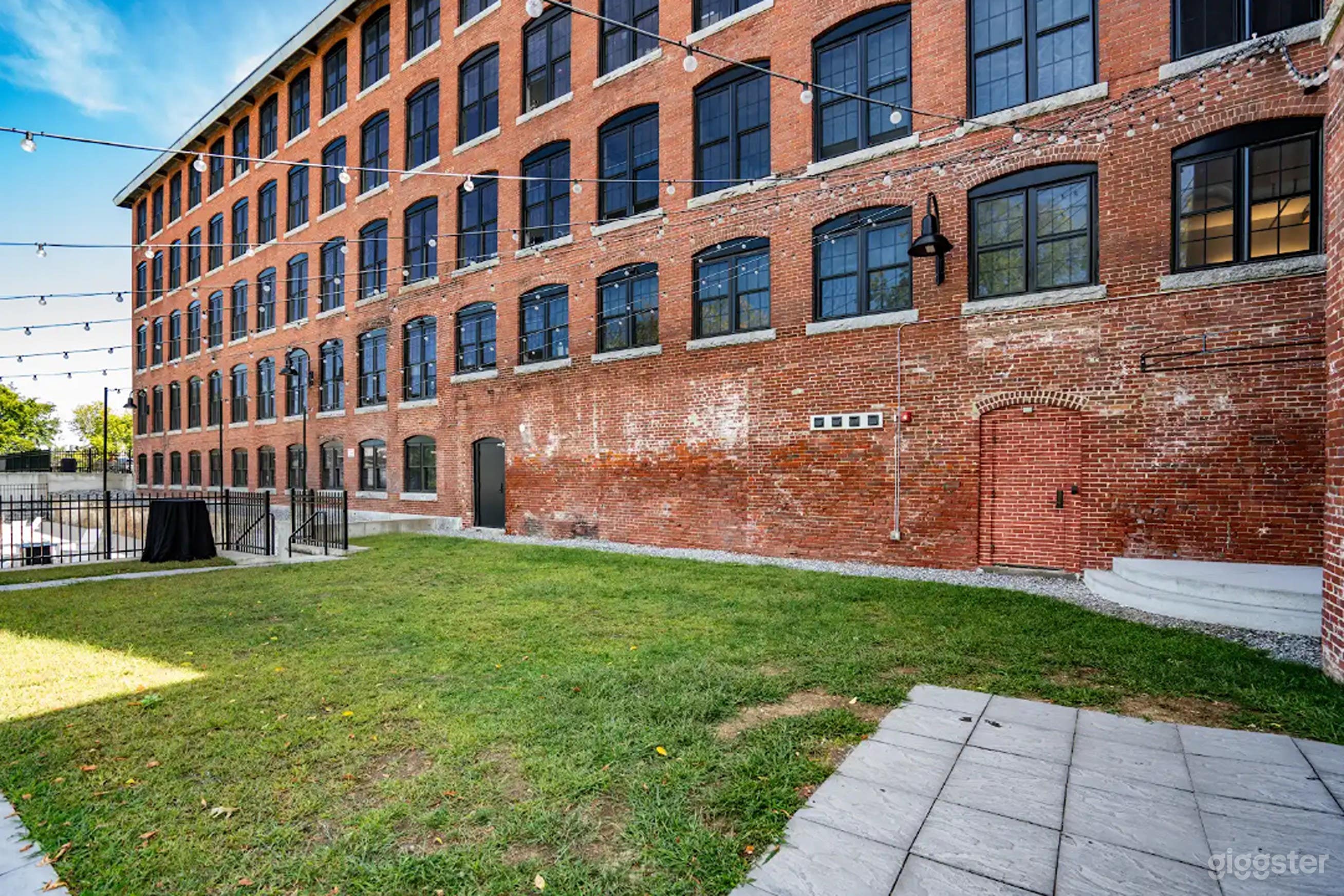 Urban Upper Courtyard with Bistro Lights & Red Brick Charm Photo 3